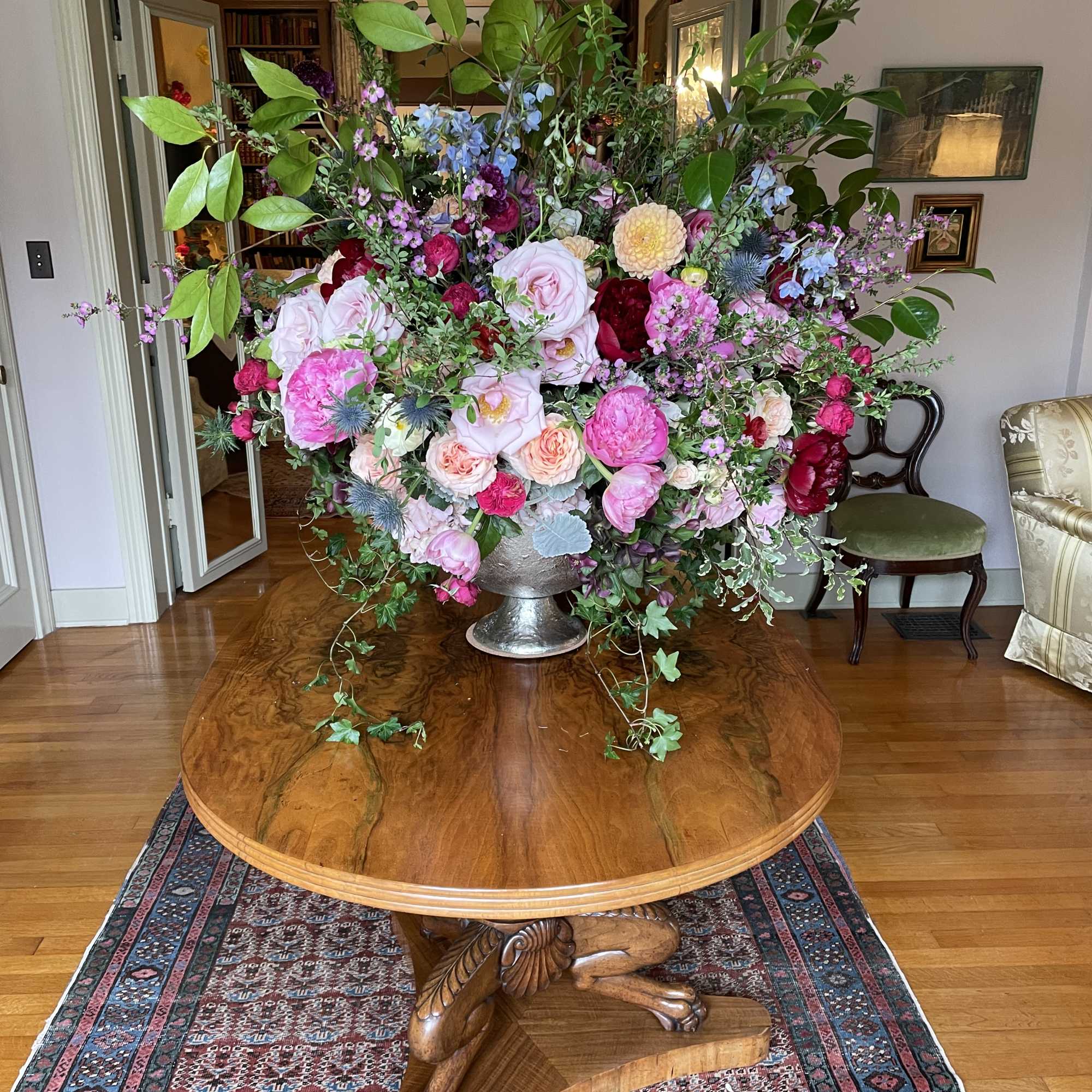 Large mixed floral arrangement in a silver pedestal vase