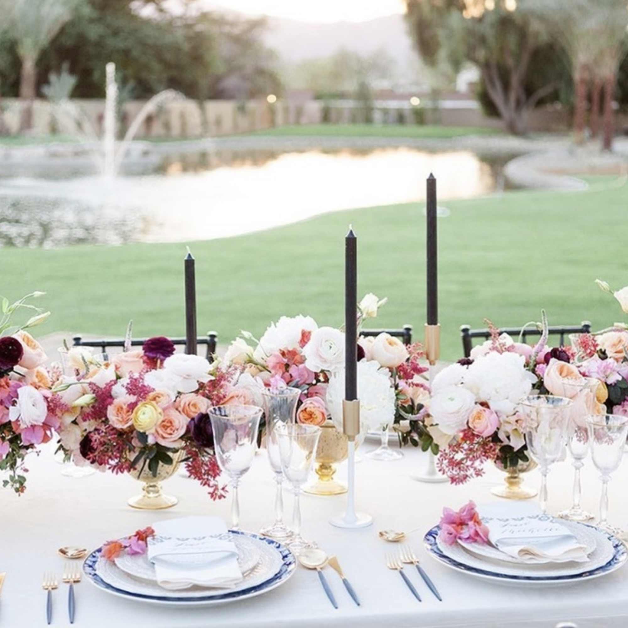 Floral table centerpiece with pink and white flowers and tall black candles