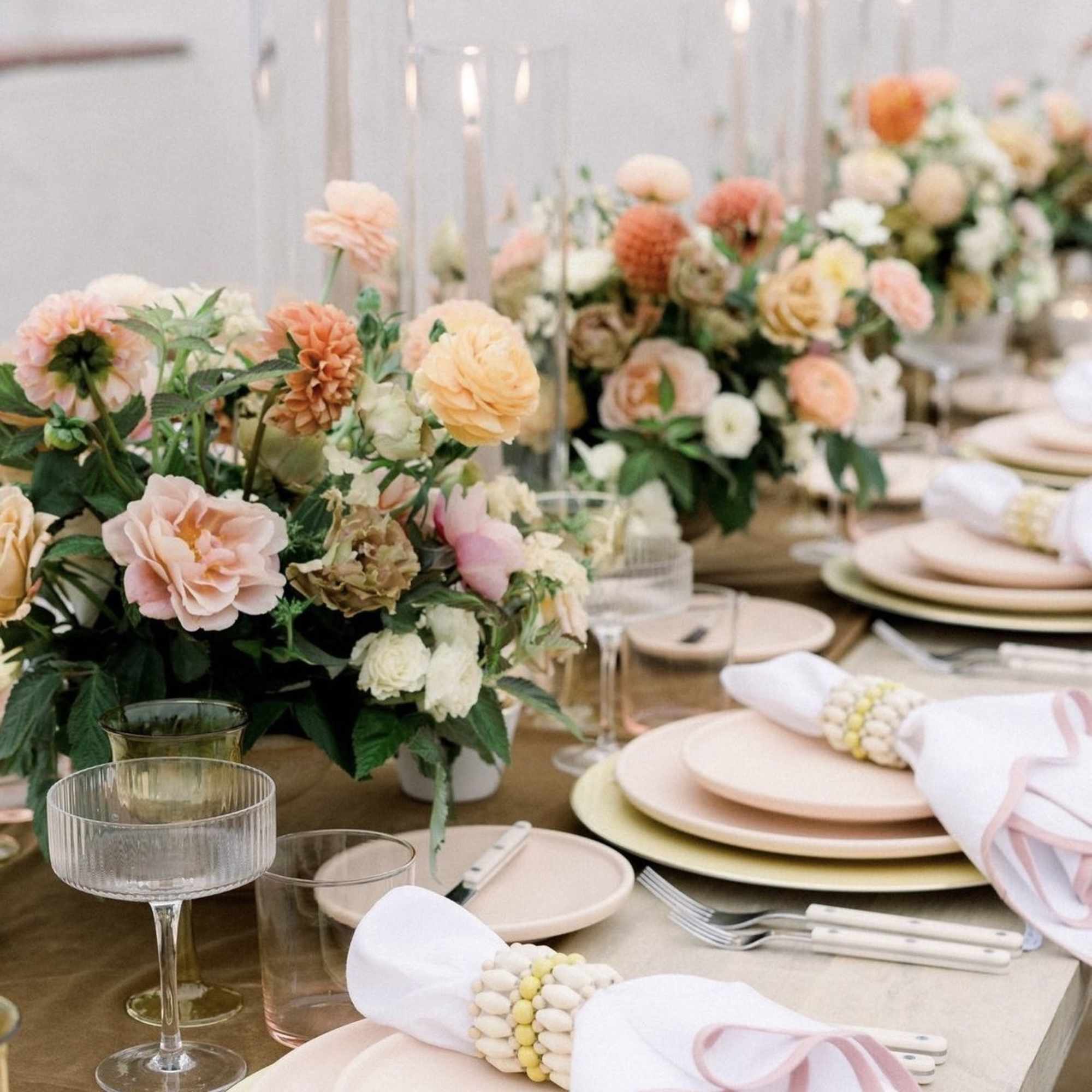 Pastel floral centerpieces on a set dining table with candles