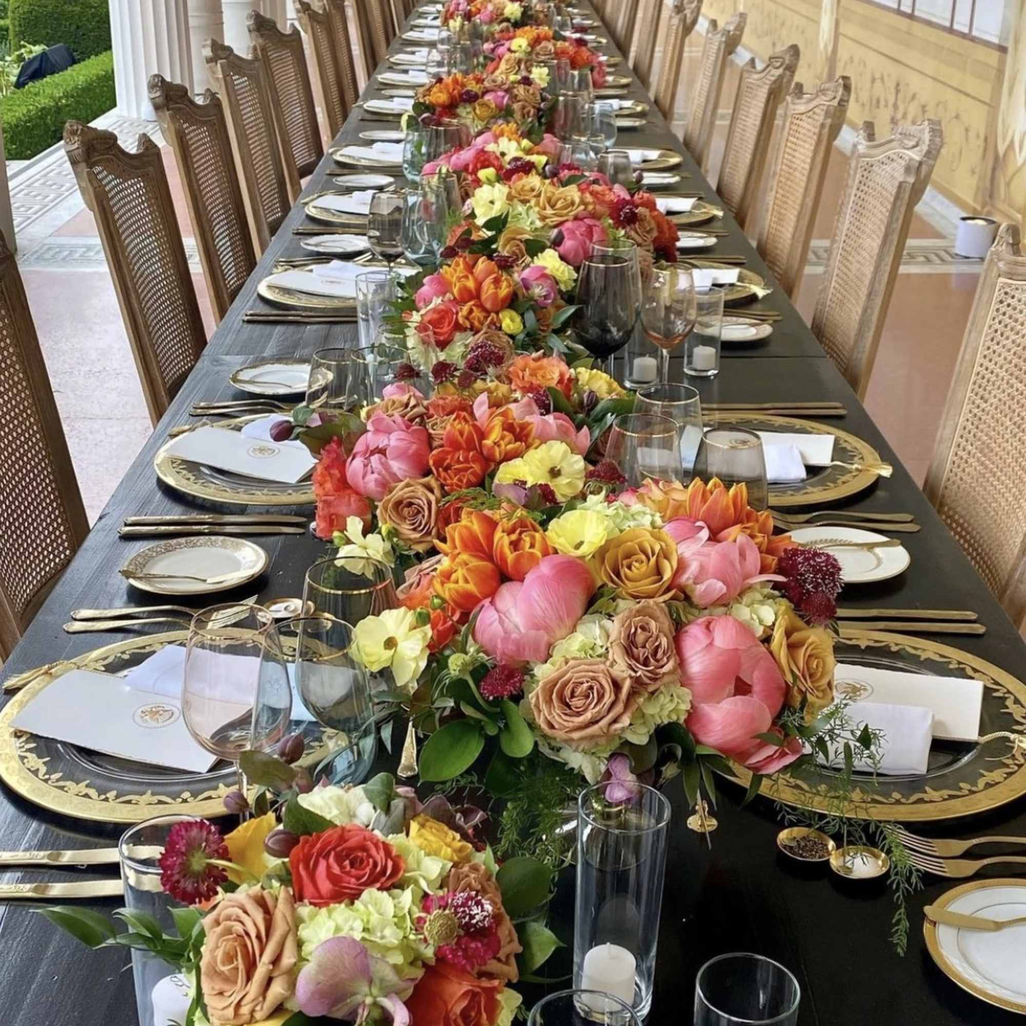 Long banquet table with colorful floral centerpieces and place settings