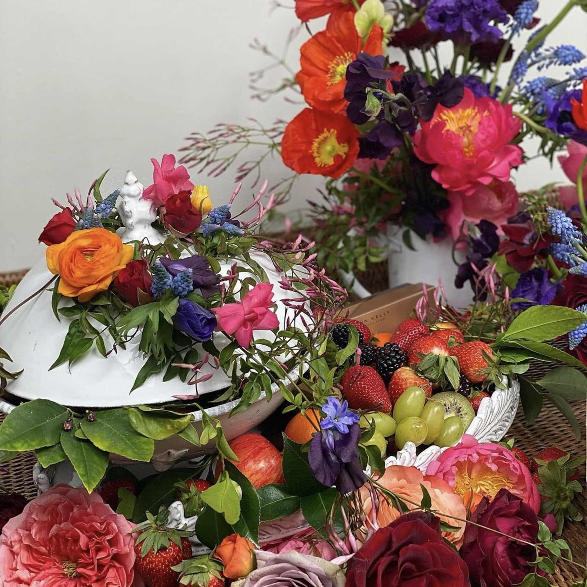 Colorful floral arrangements with fruit in decorative containers