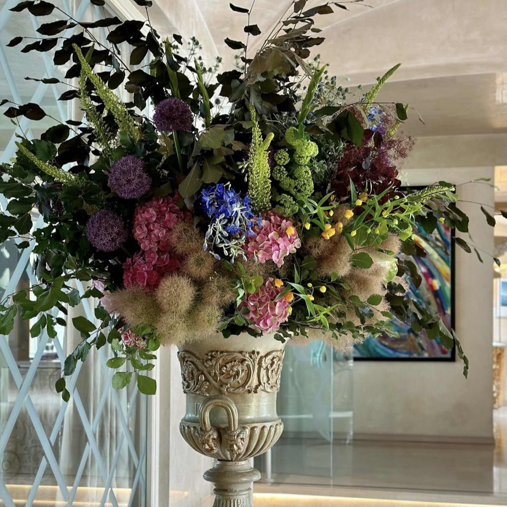 Large mixed floral arrangement in an ornate pedestal urn