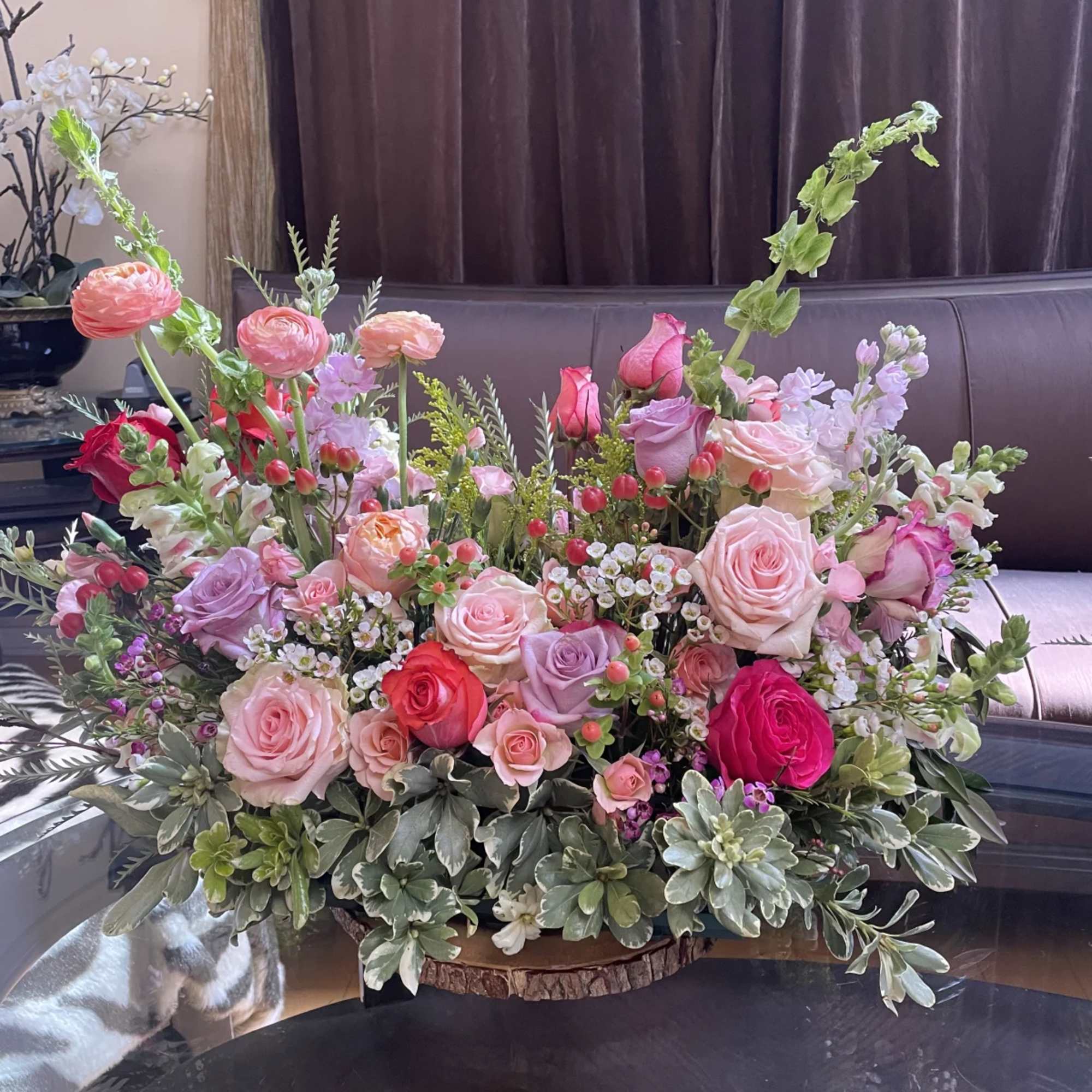 Mixed pink and lavender roses in a low floral centerpiece