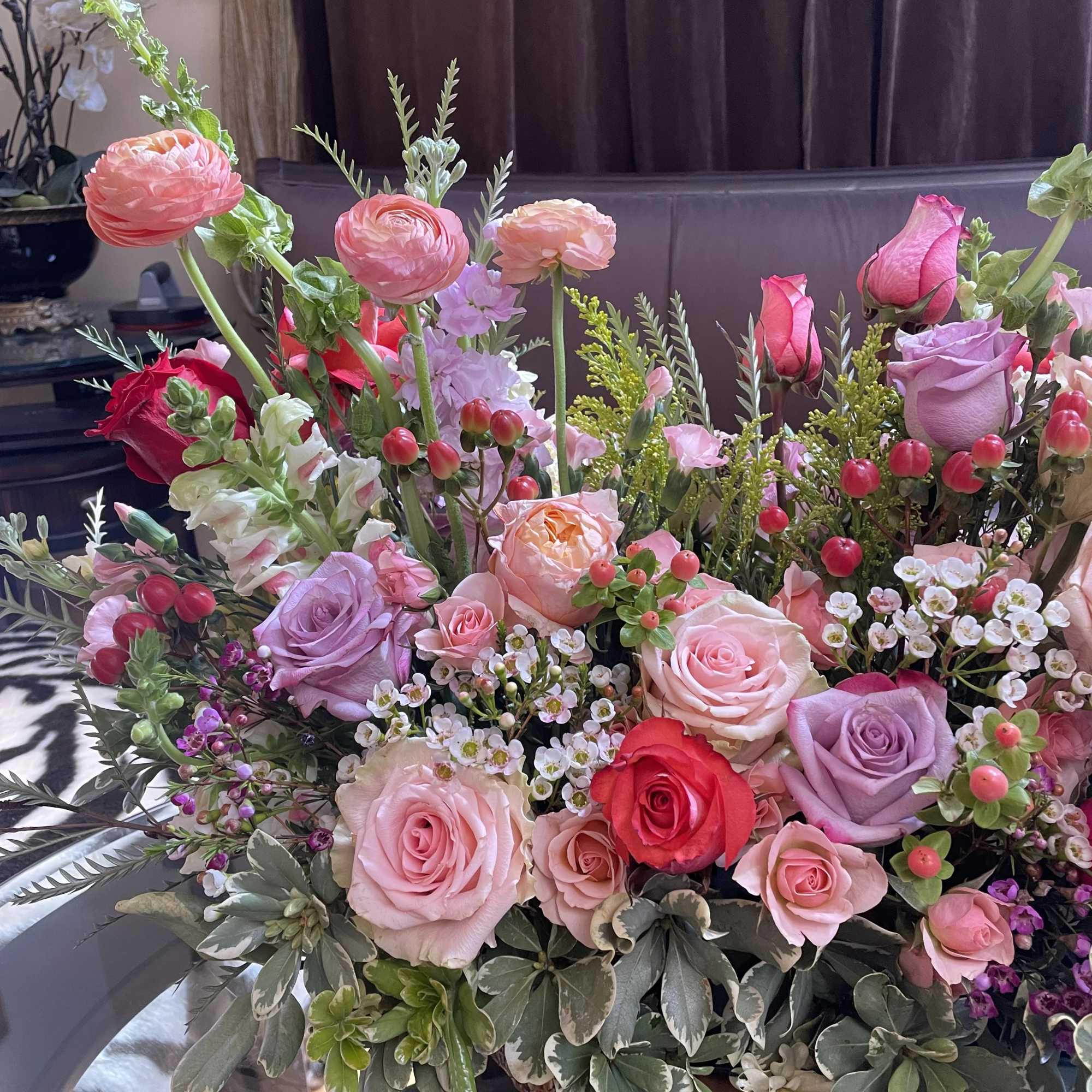 Mixed pink and lavender roses in a low wooden arrangement