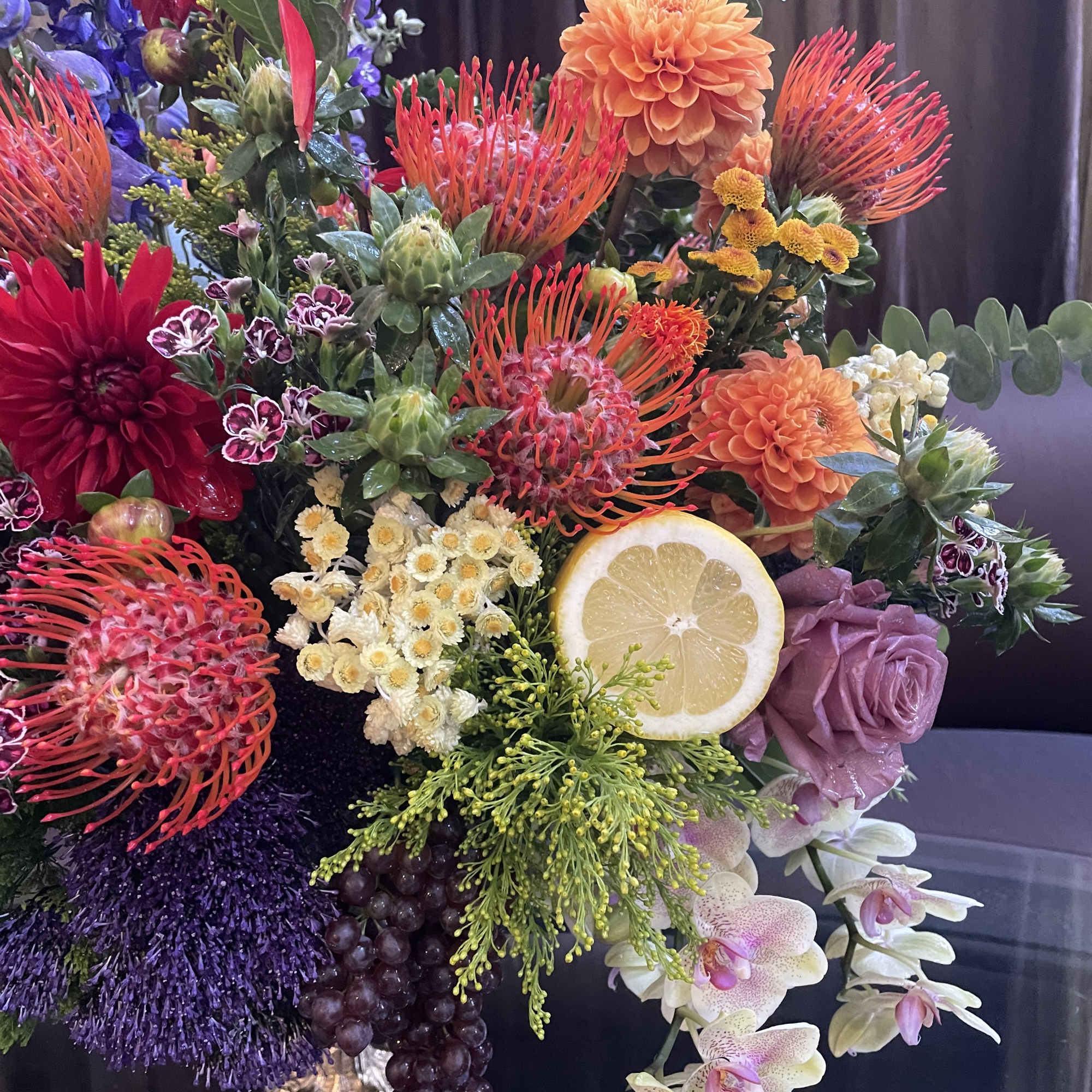 Colorful mixed bouquet with orchids, dahlias, and a lemon slice