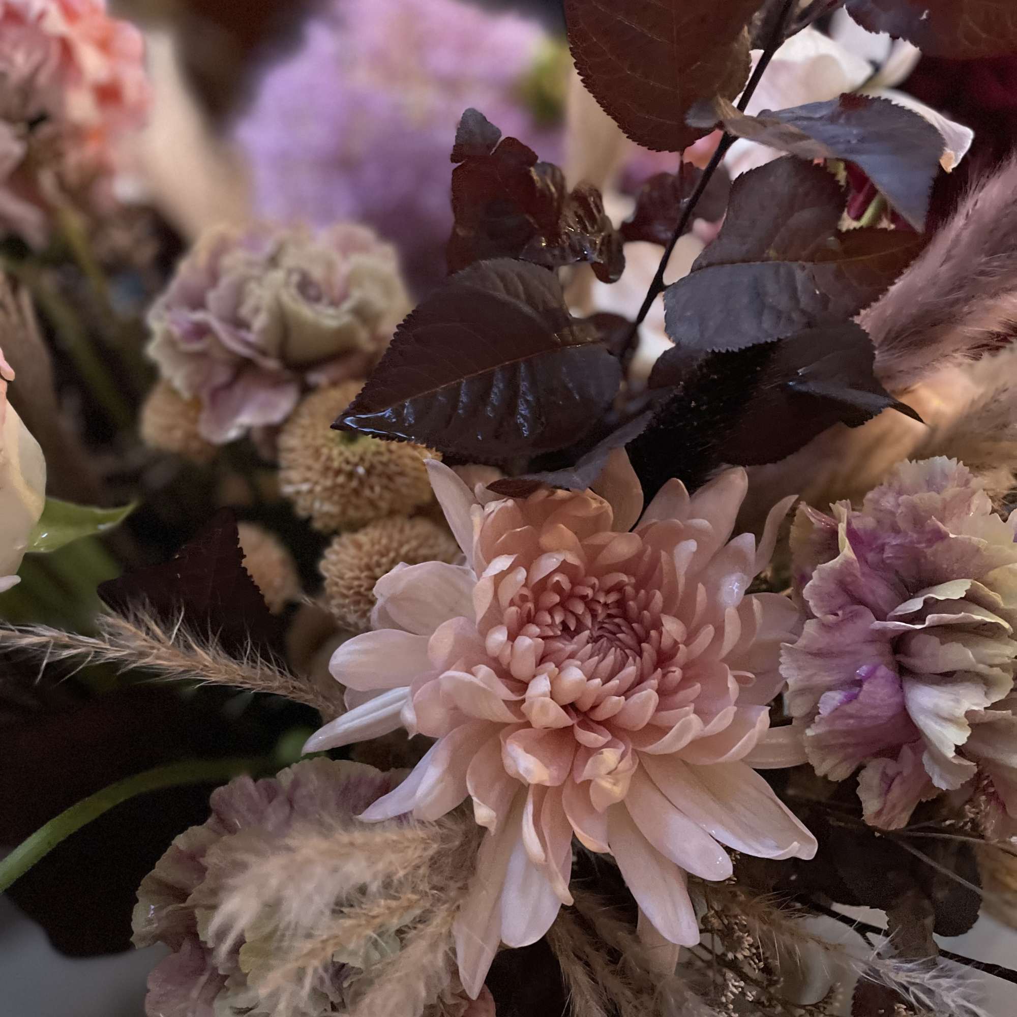 Bouquet of pale pink and lavender flowers with dark foliage