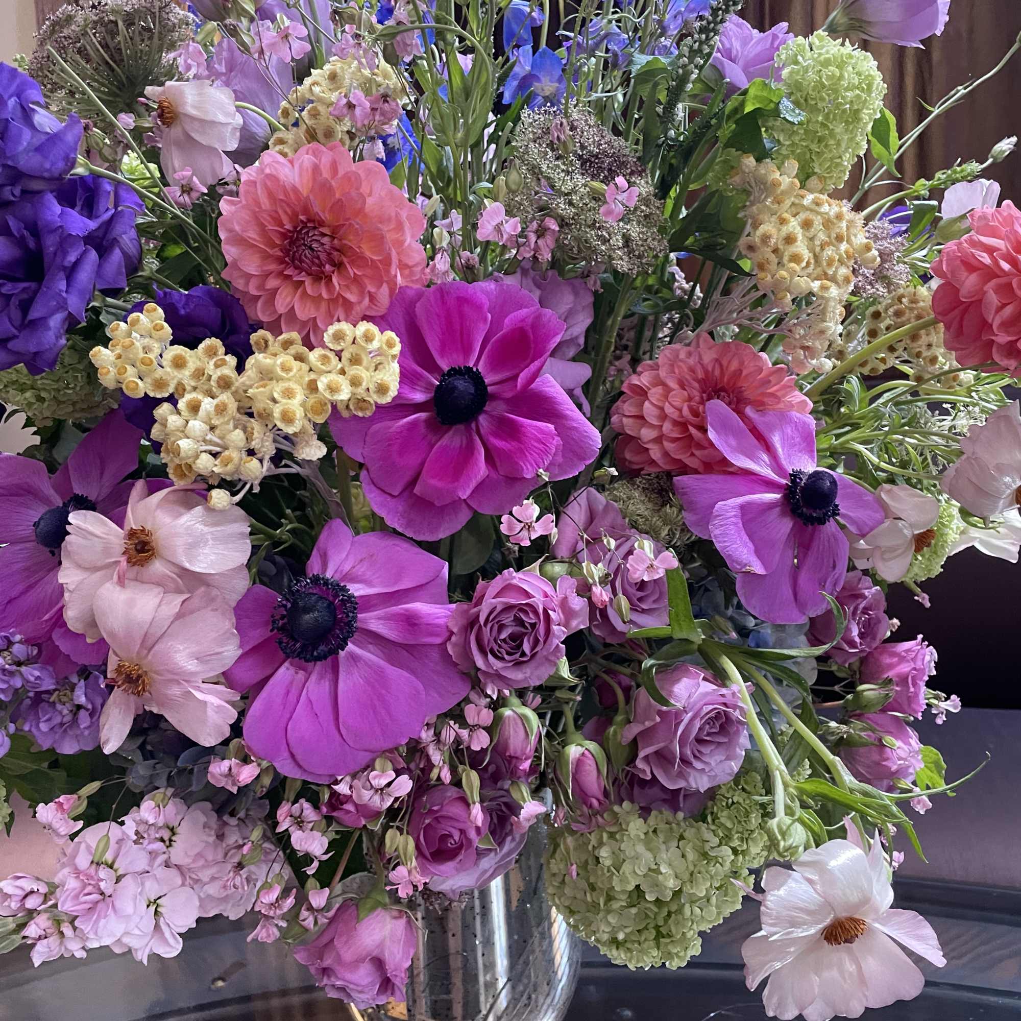 Mixed pink and purple floral arrangement in a silver vase