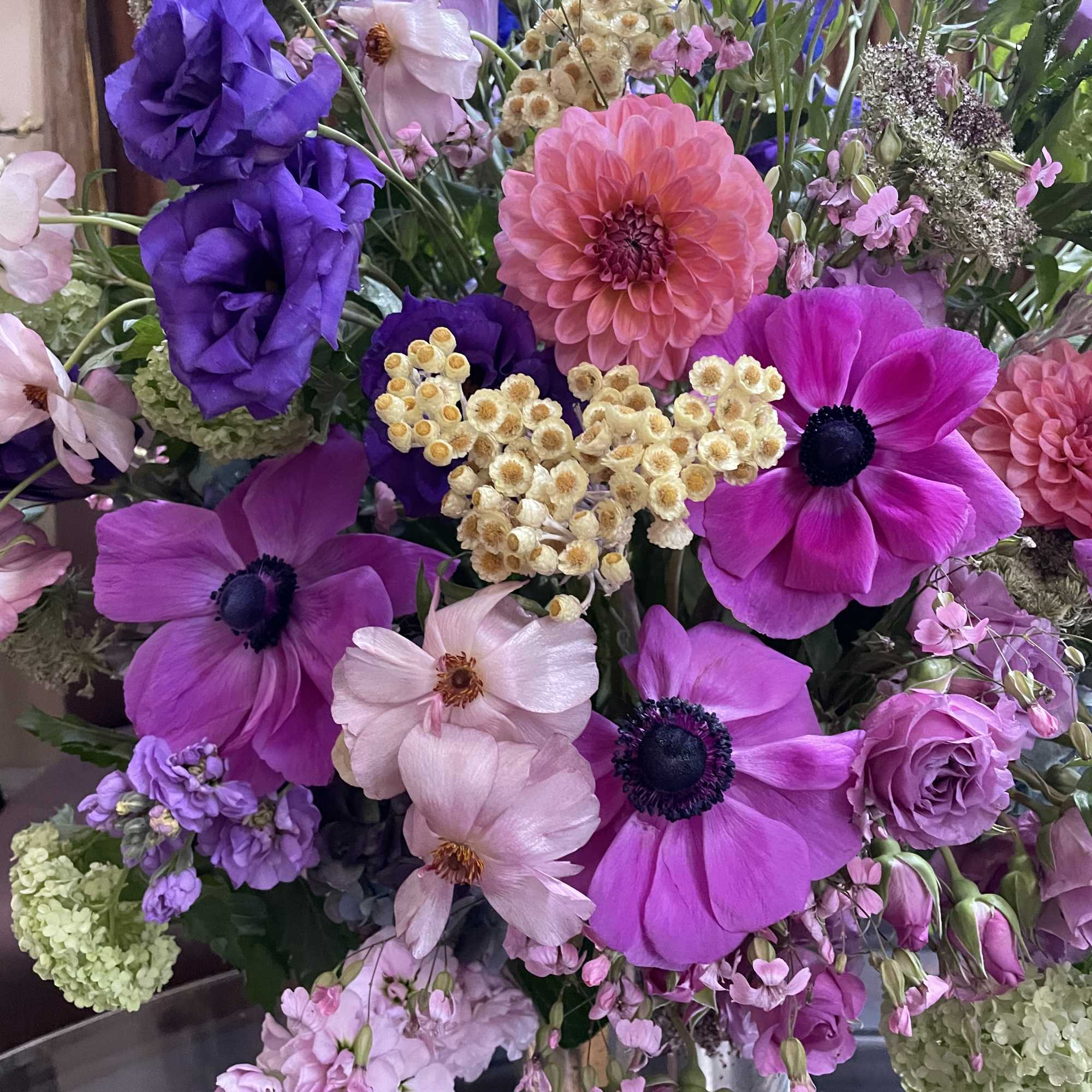 Bouquet of pink, purple, and peach flowers in a clear vase