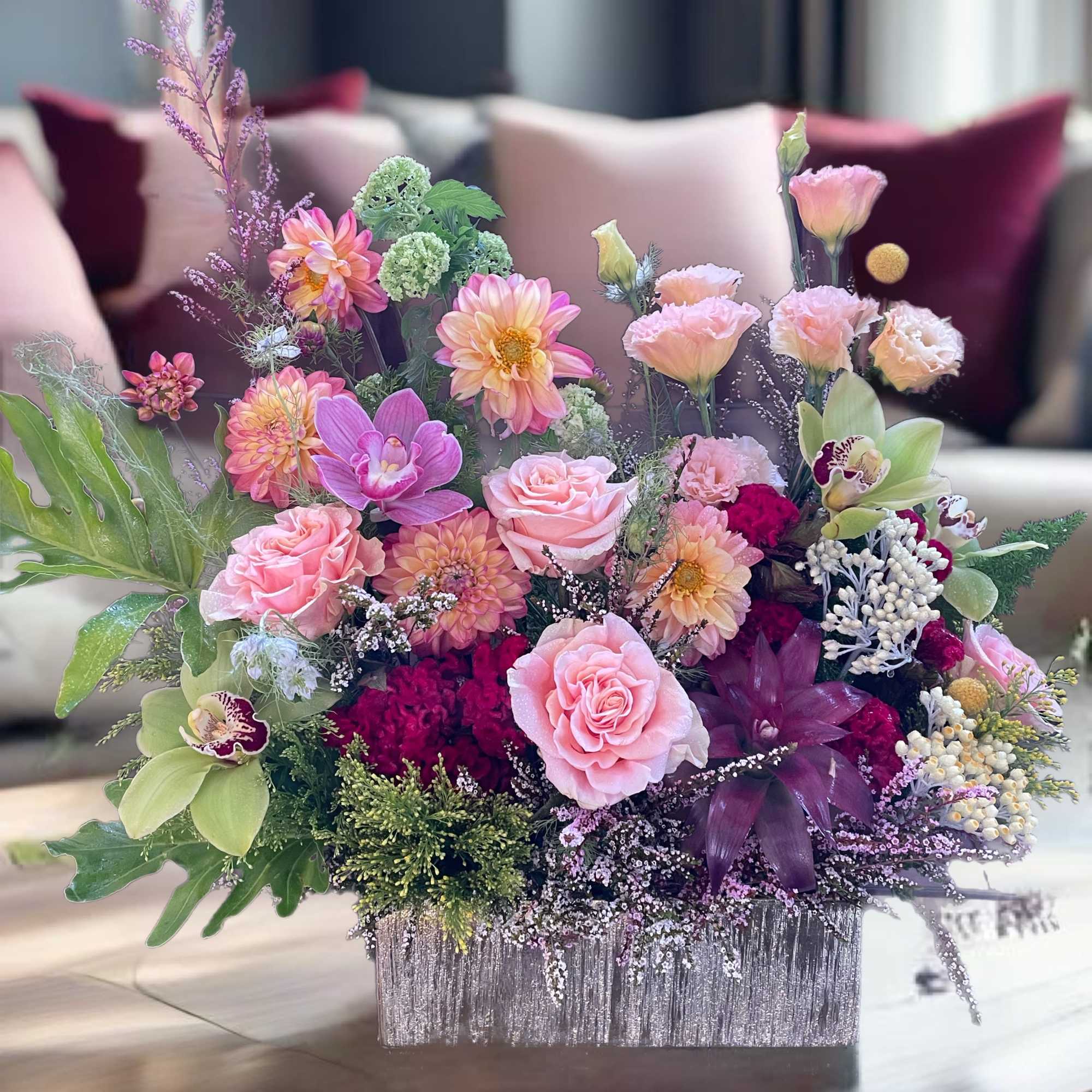 Pink and peach floral arrangement in a silver rectangular container