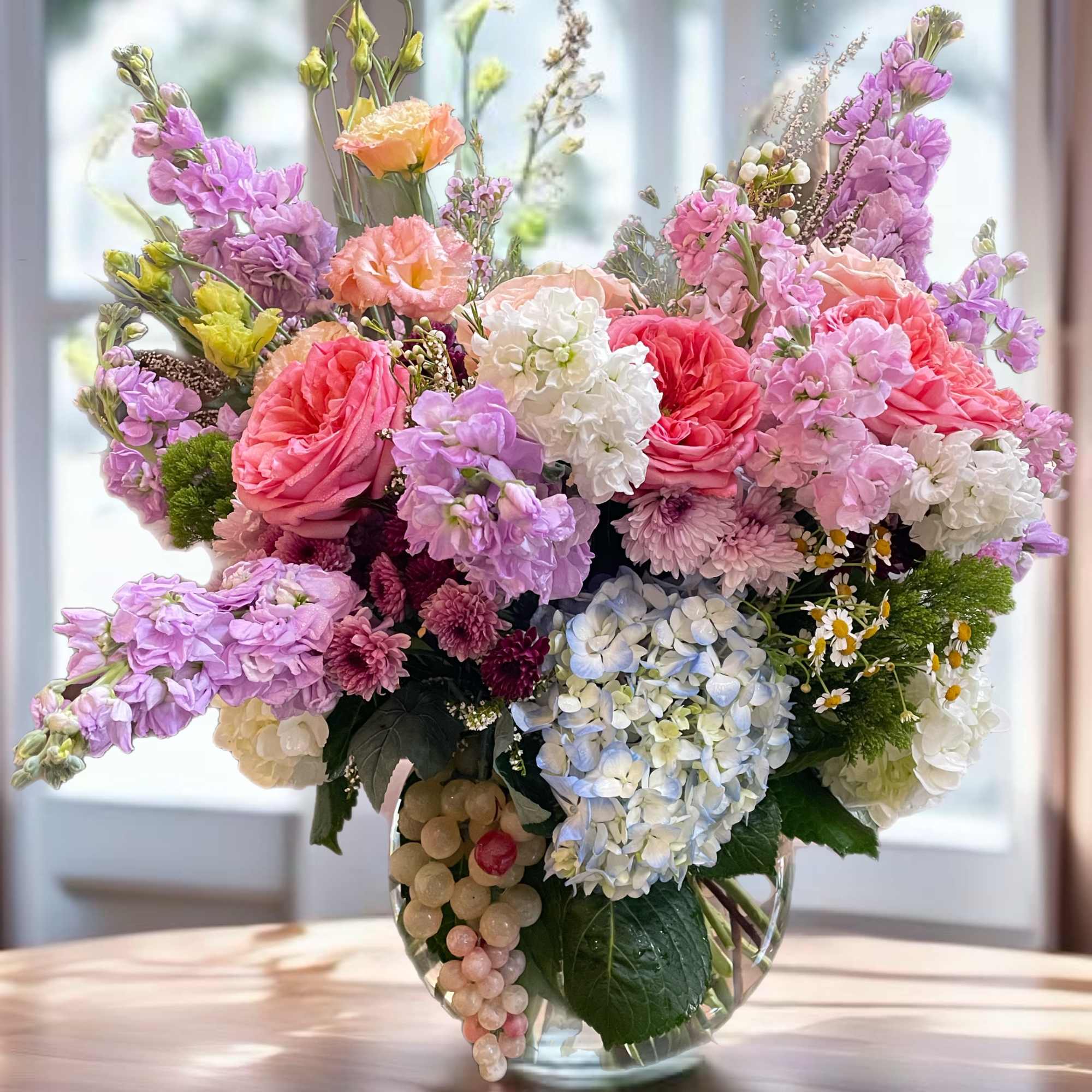 Large pastel bouquet in a clear glass vase
