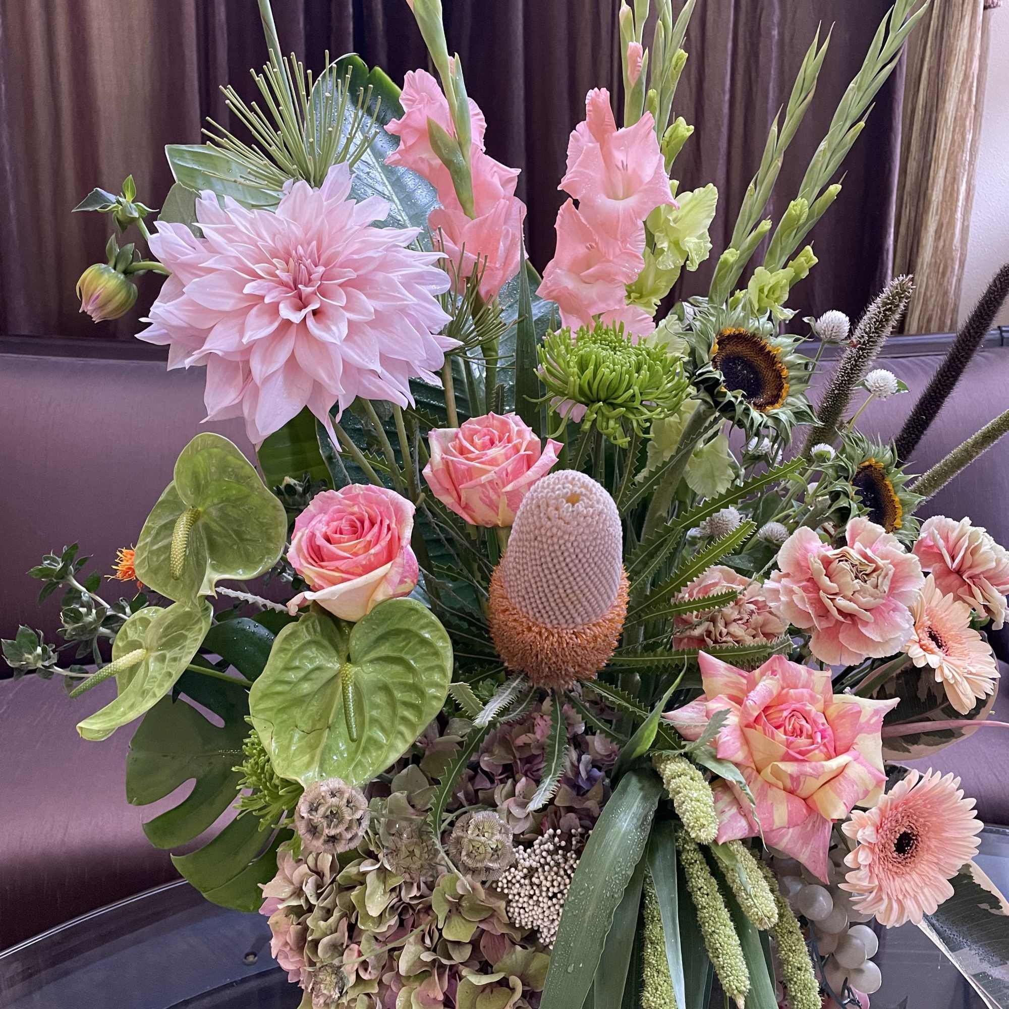 Large mixed floral arrangement with pink blooms and tropical accents