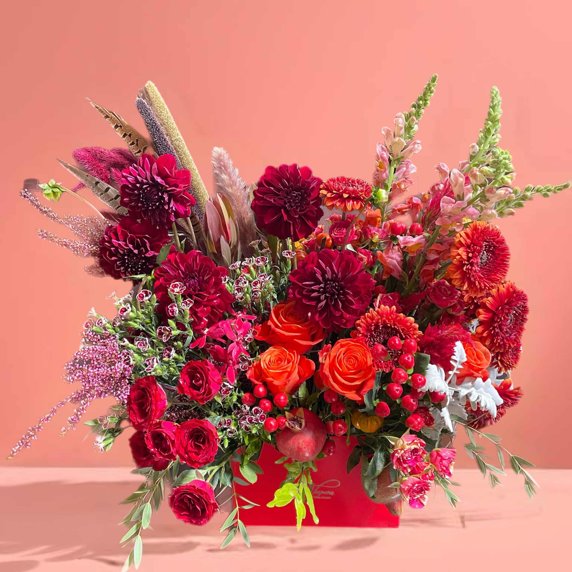 Large red and orange floral arrangement in a red box