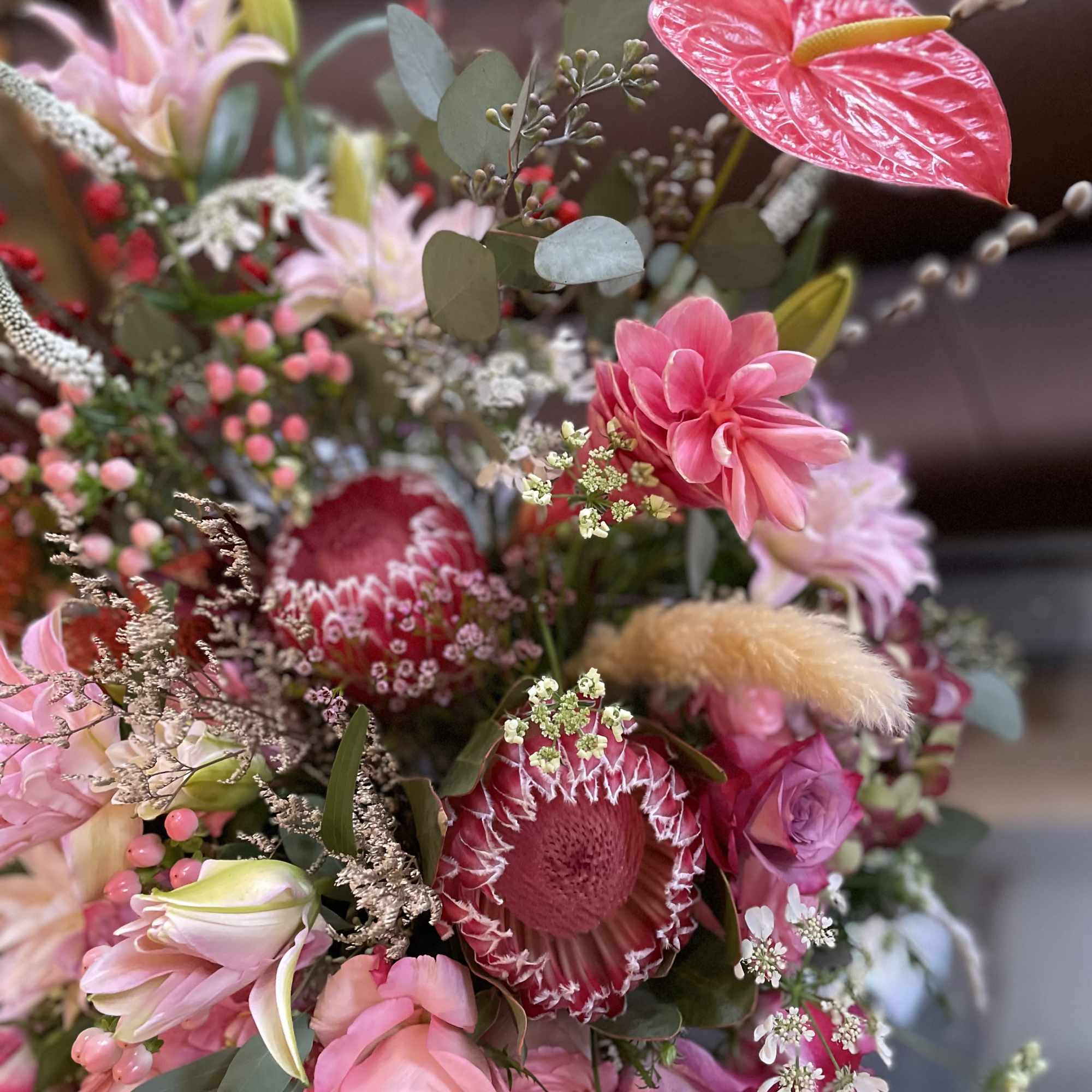 Pink and red mixed bouquet with protea, roses, and lilies