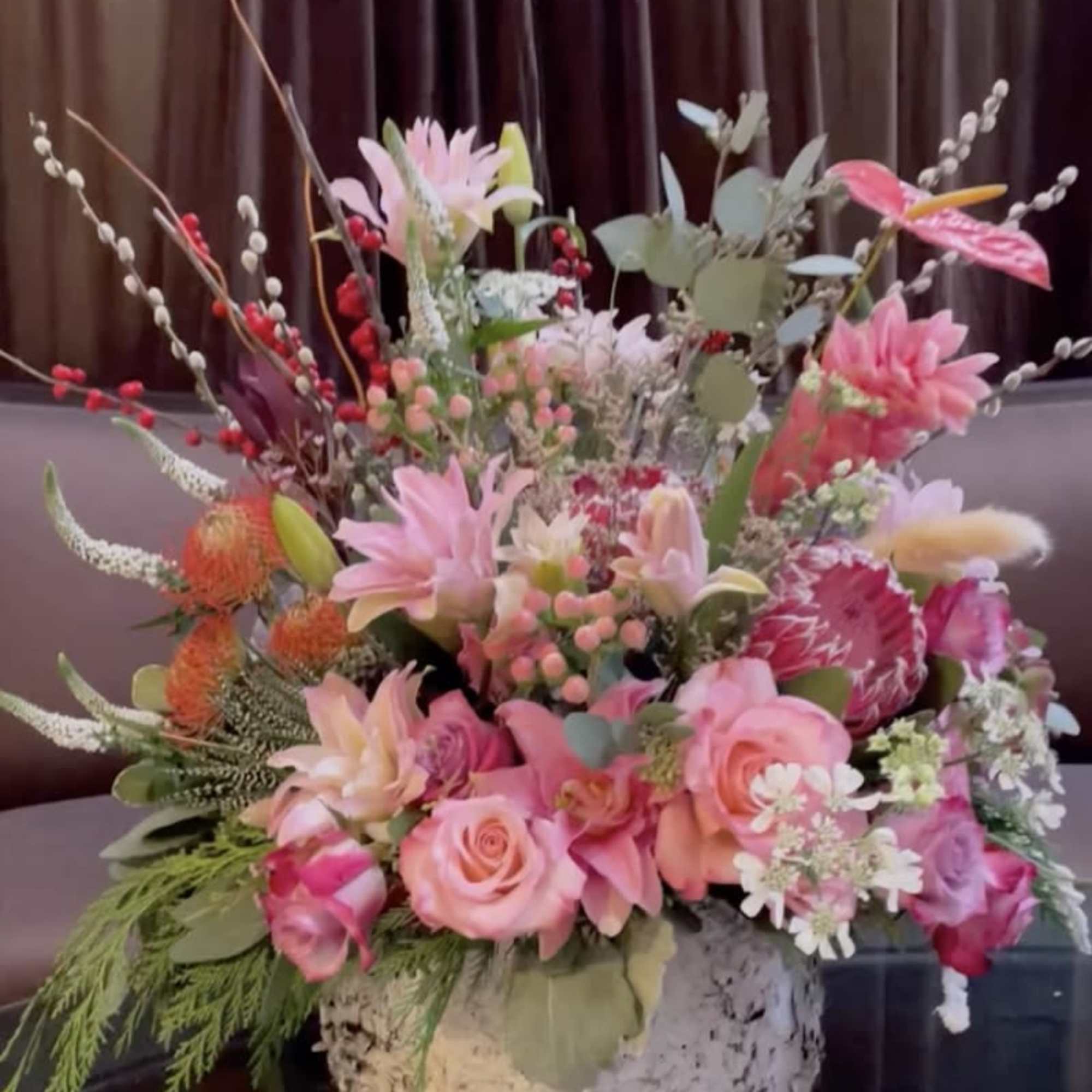 Pink and peach floral arrangement in a low white container