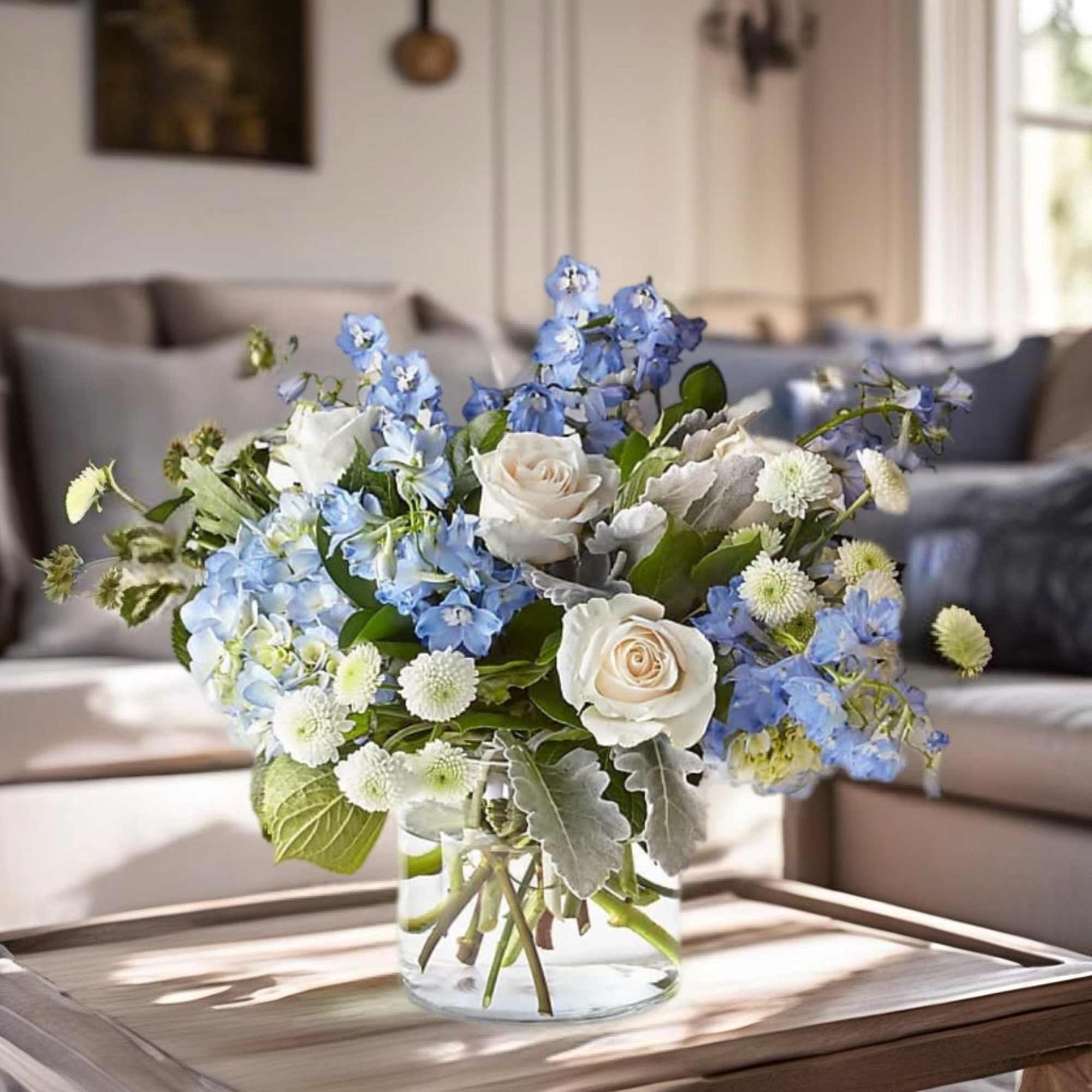 Blue and white flowers arranged in a clear glass vase on a table
