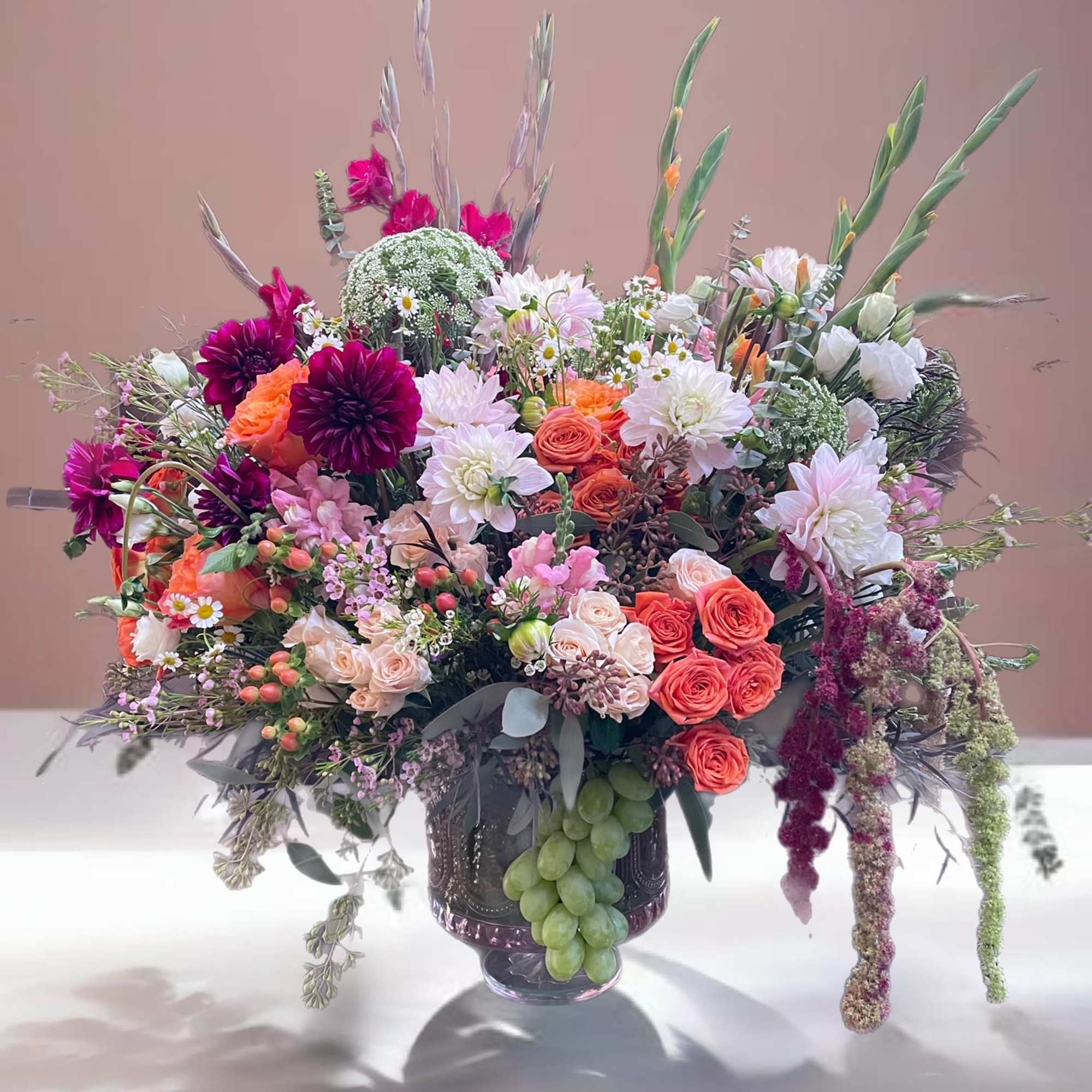Large mixed bouquet in a glass vase with pink, white, and orange flowers