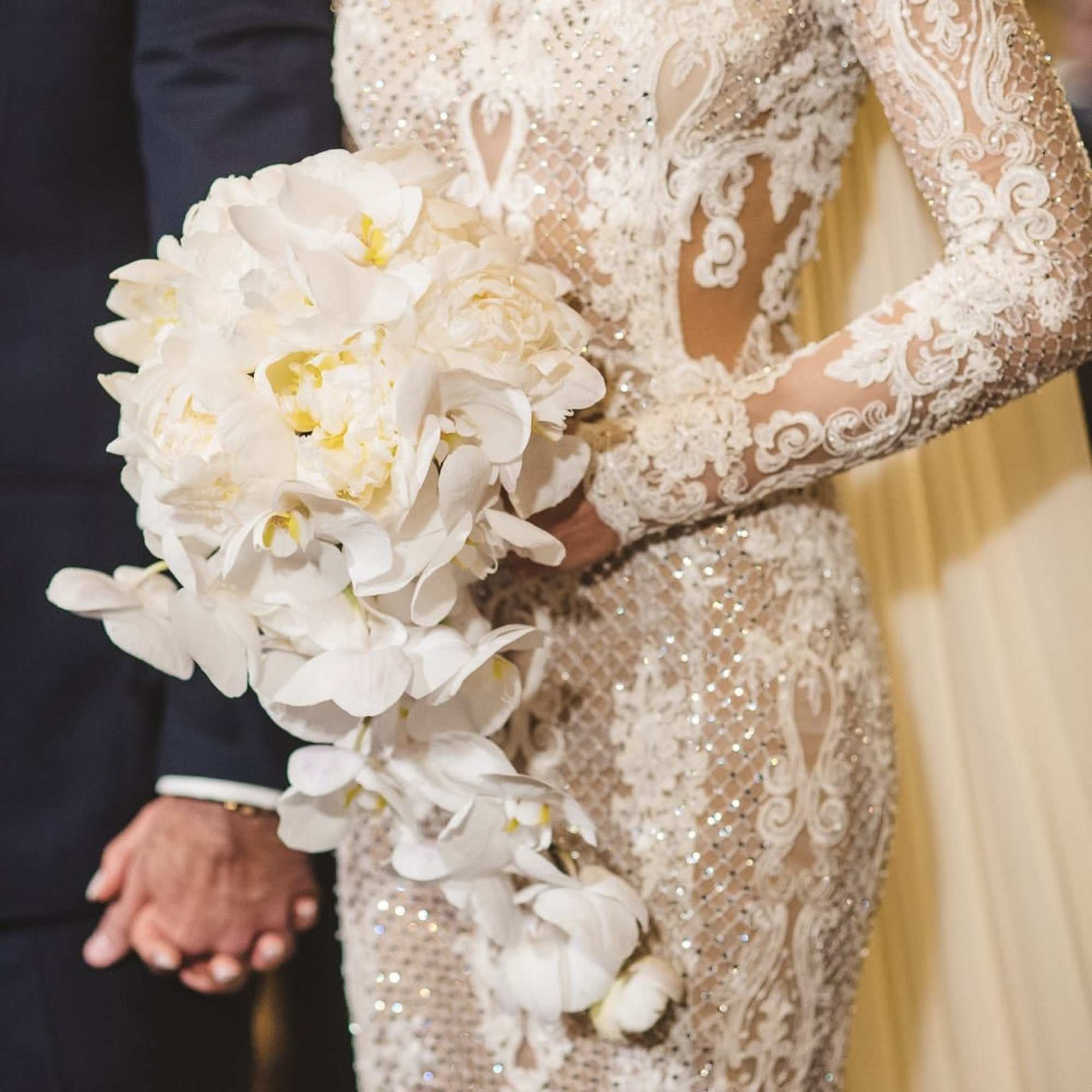 Bride holding a cascading white orchid bouquet