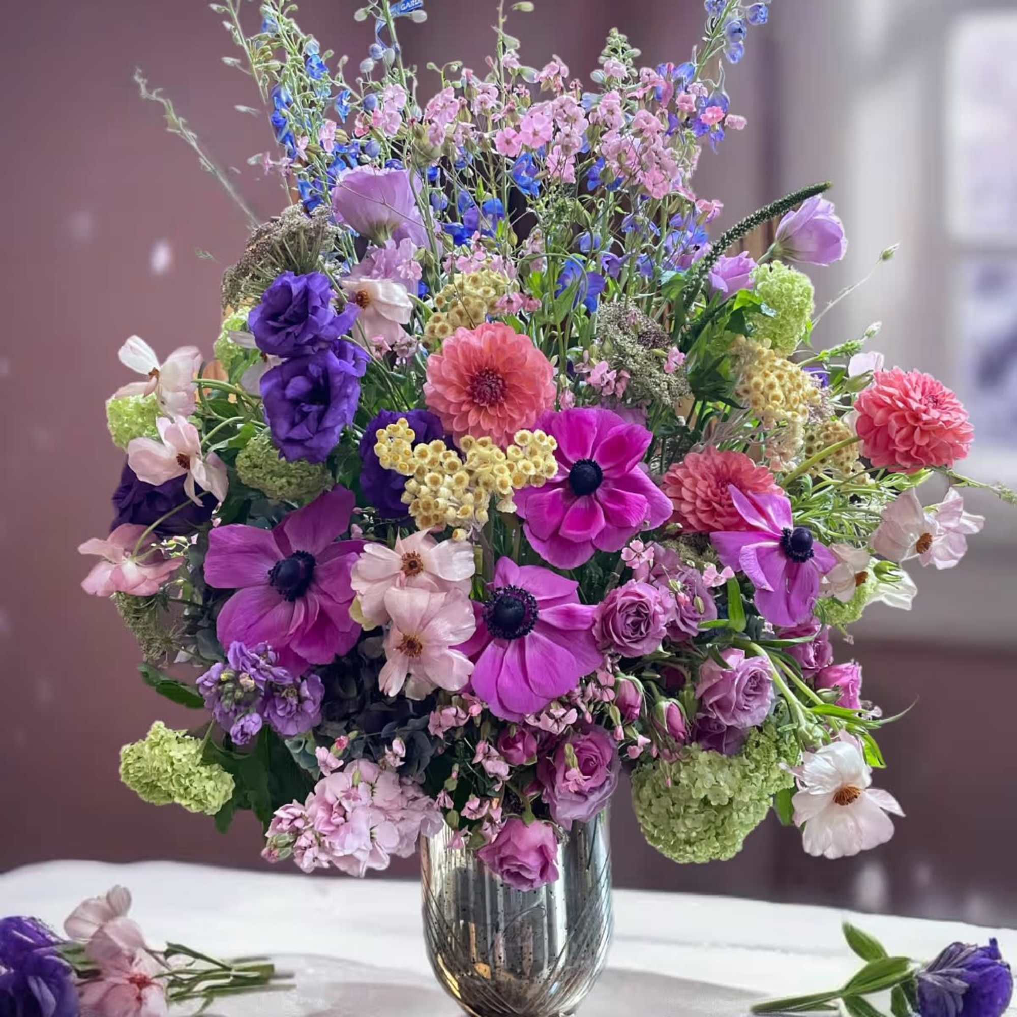 Mixed pink and purple flower arrangement in a glass vase
