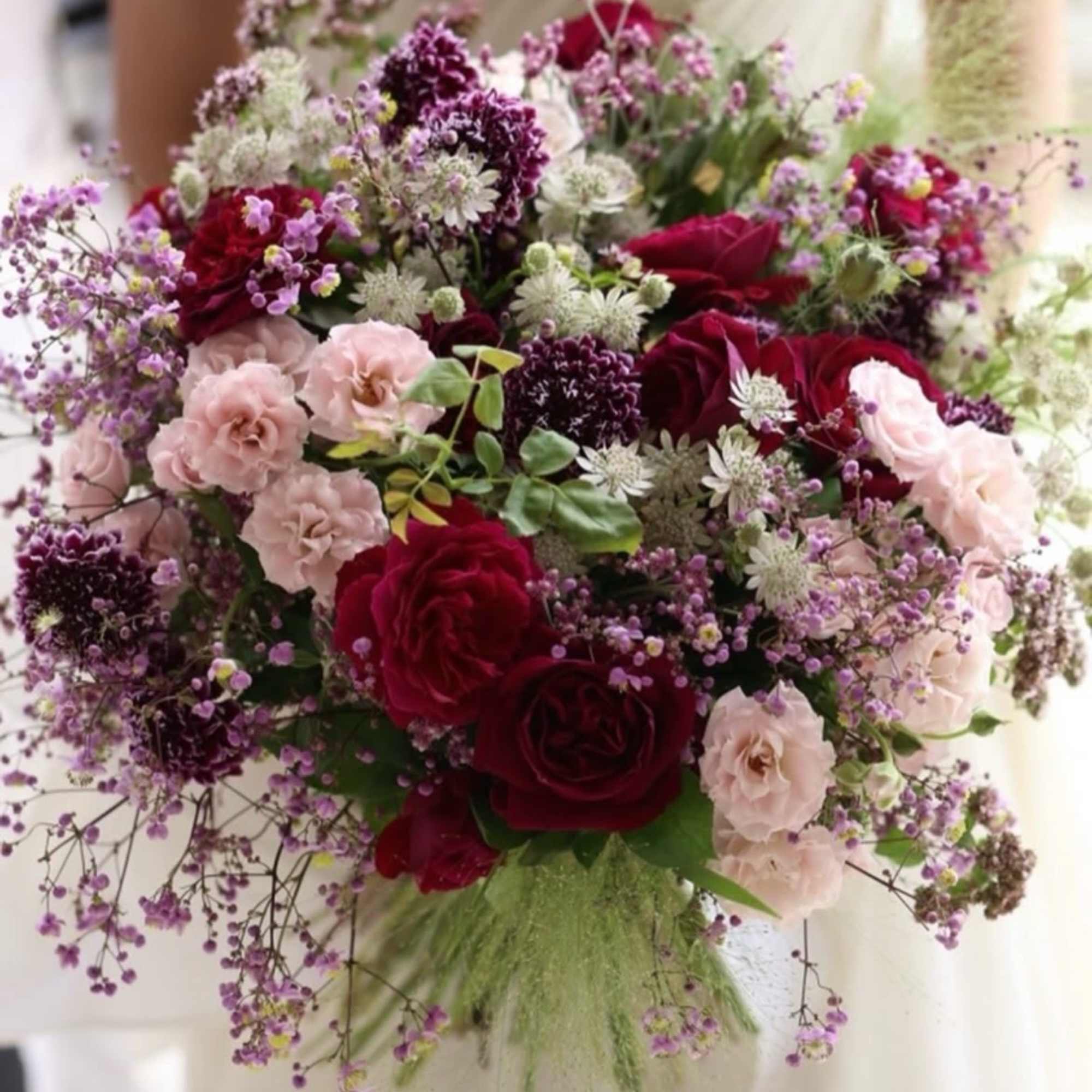 Bouquet of red and blush roses with purple filler flowers