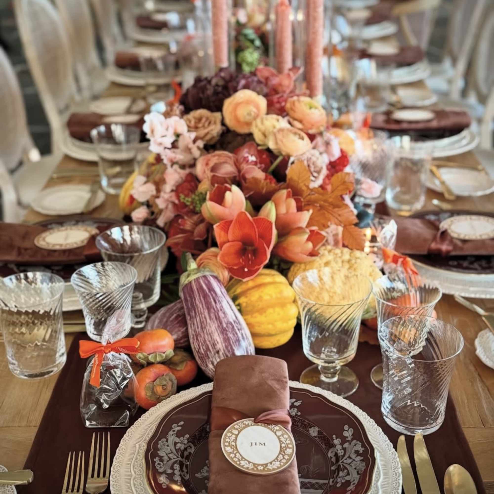 Autumn table centerpiece with orange flowers and pumpkins on a set dining table
