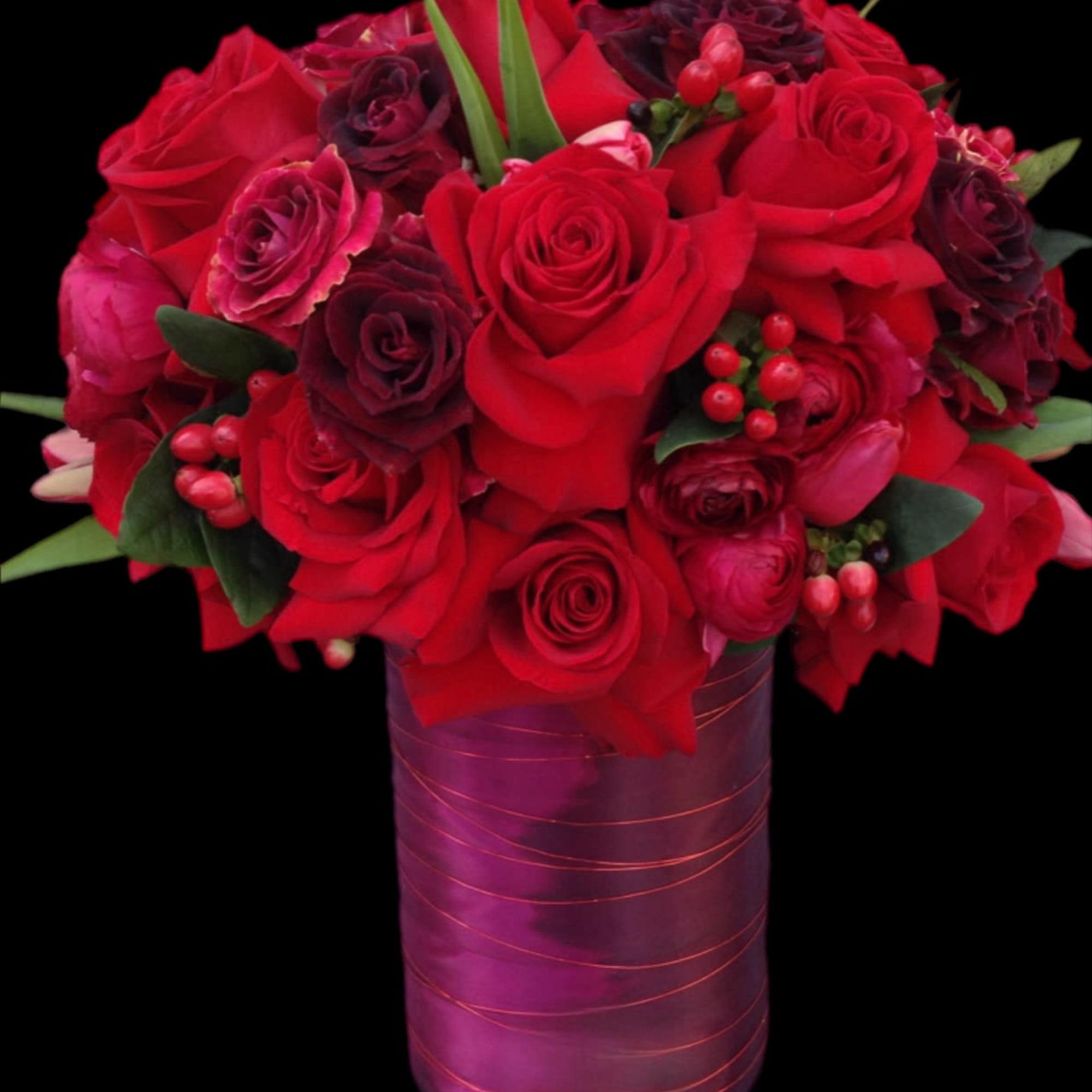 Red and burgundy rose bouquet in a purple vase