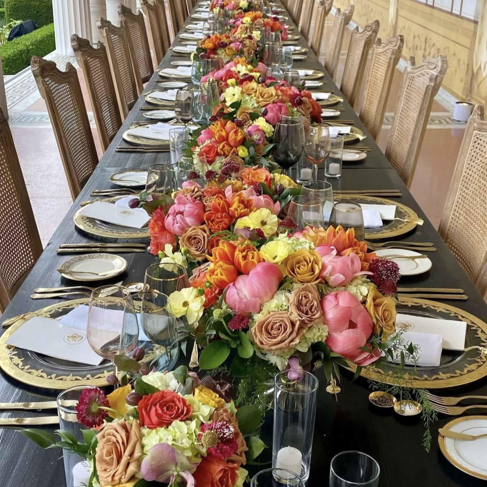 Long banquet table with colorful floral centerpieces and place settings