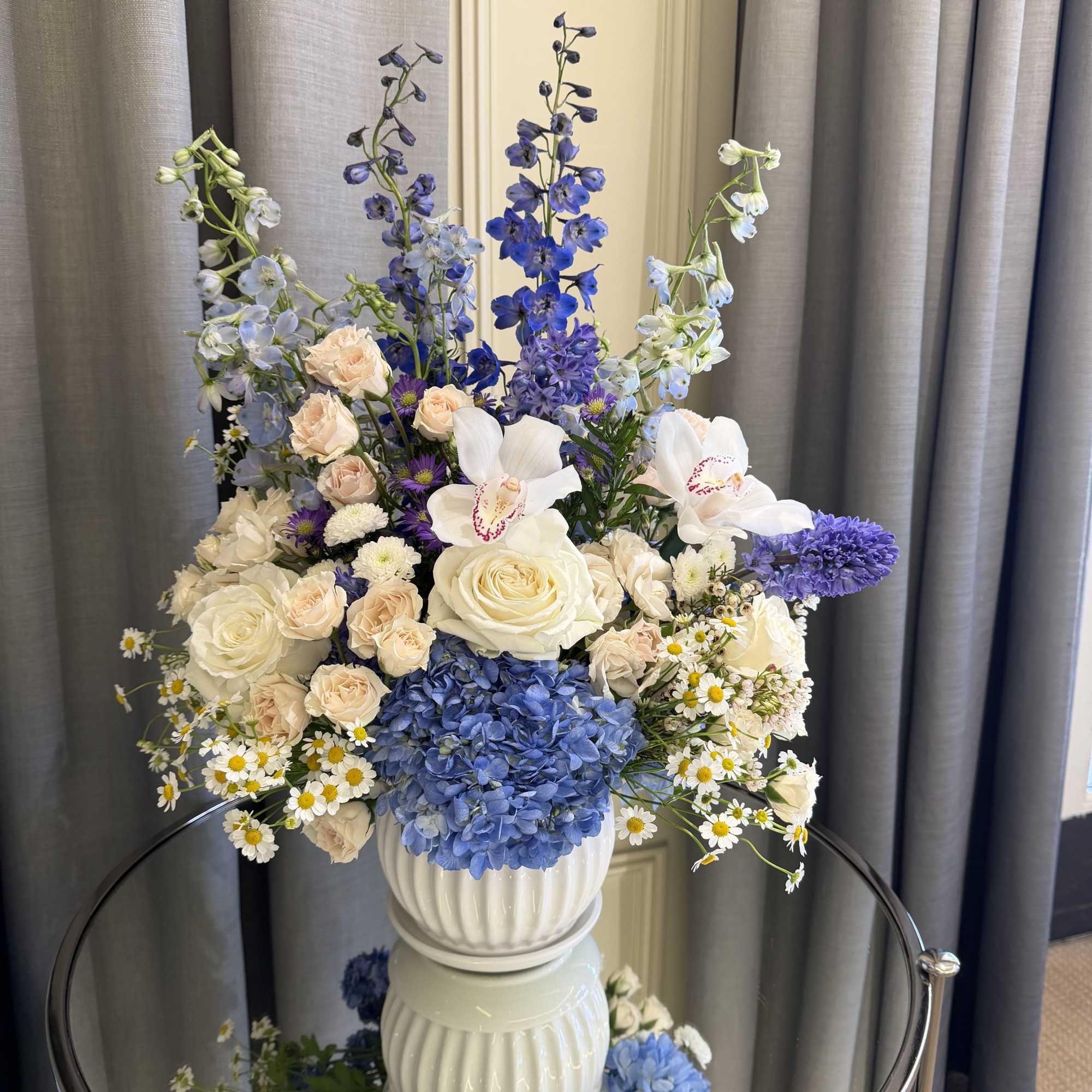 Blue and white floral arrangement in a white vase