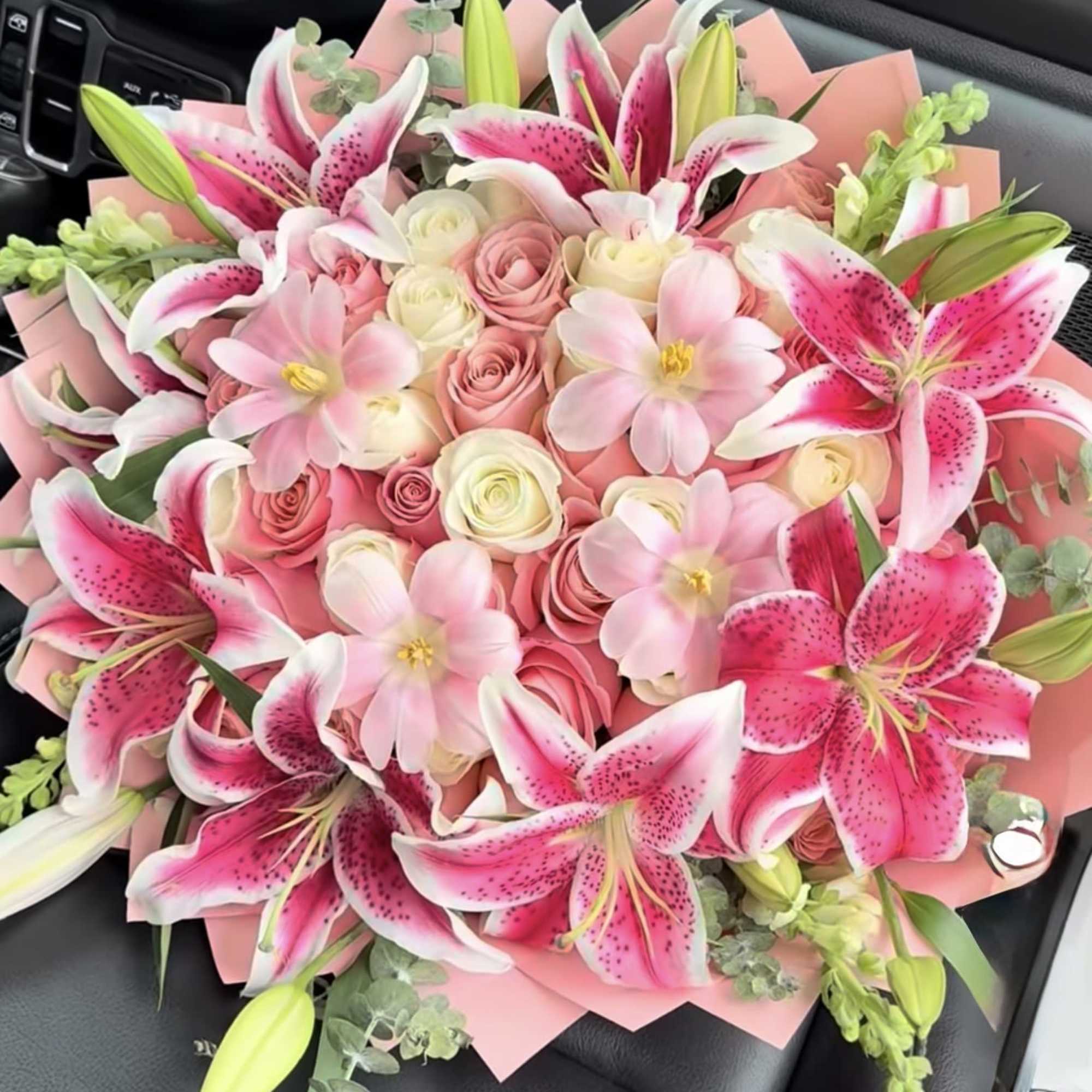 Pink lily and rose bouquet wrapped in pink paper
