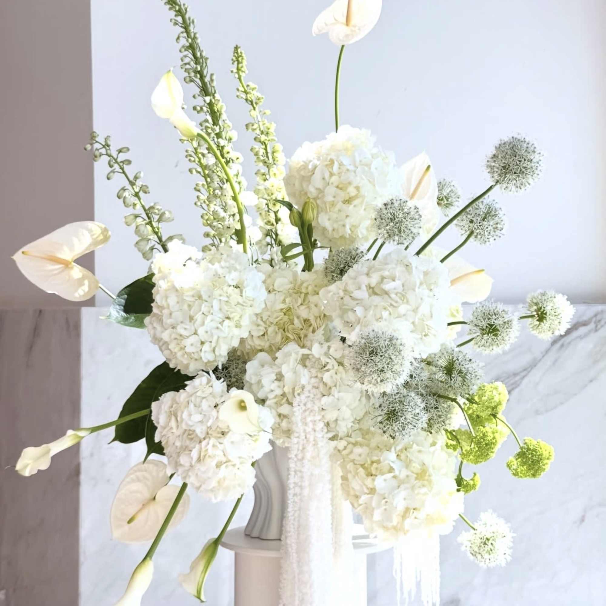 White floral arrangement with calla lilies and hydrangeas in a vase