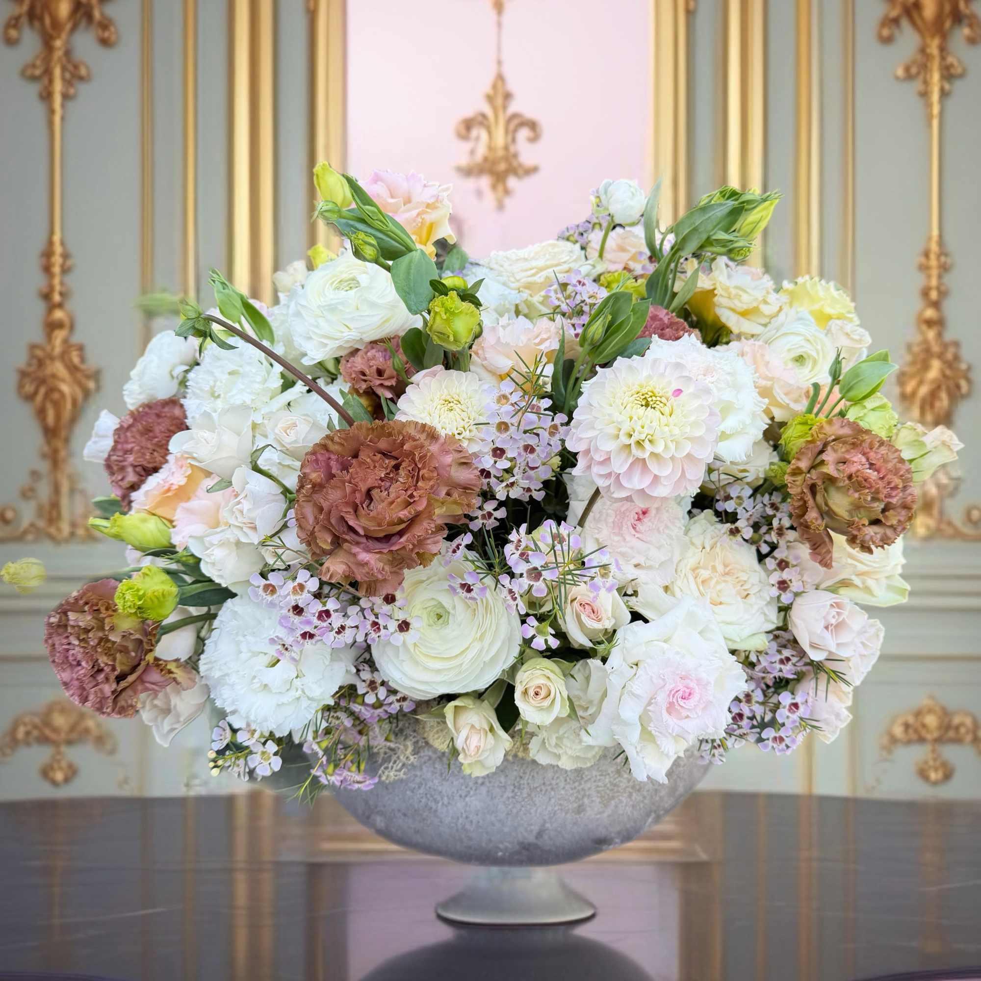Large pastel floral arrangement in a gray pedestal bowl
