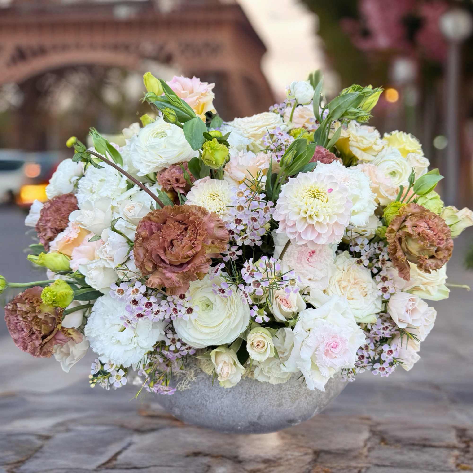 Large pastel floral arrangement in a gray bowl vase