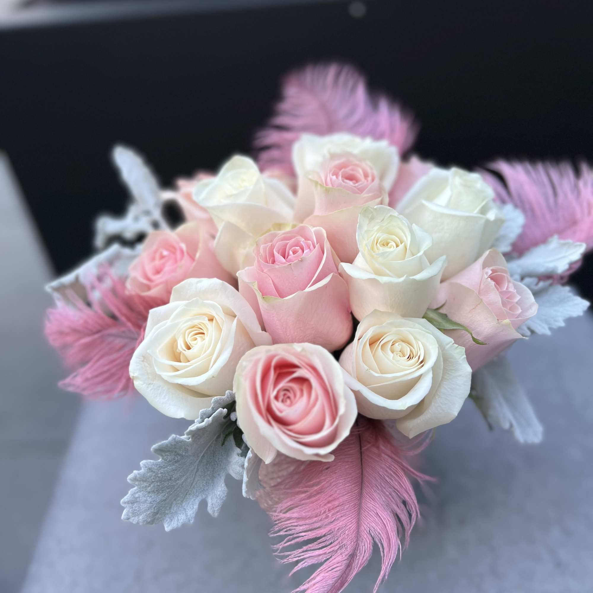 Bouquet of pink and white roses with pink feathers