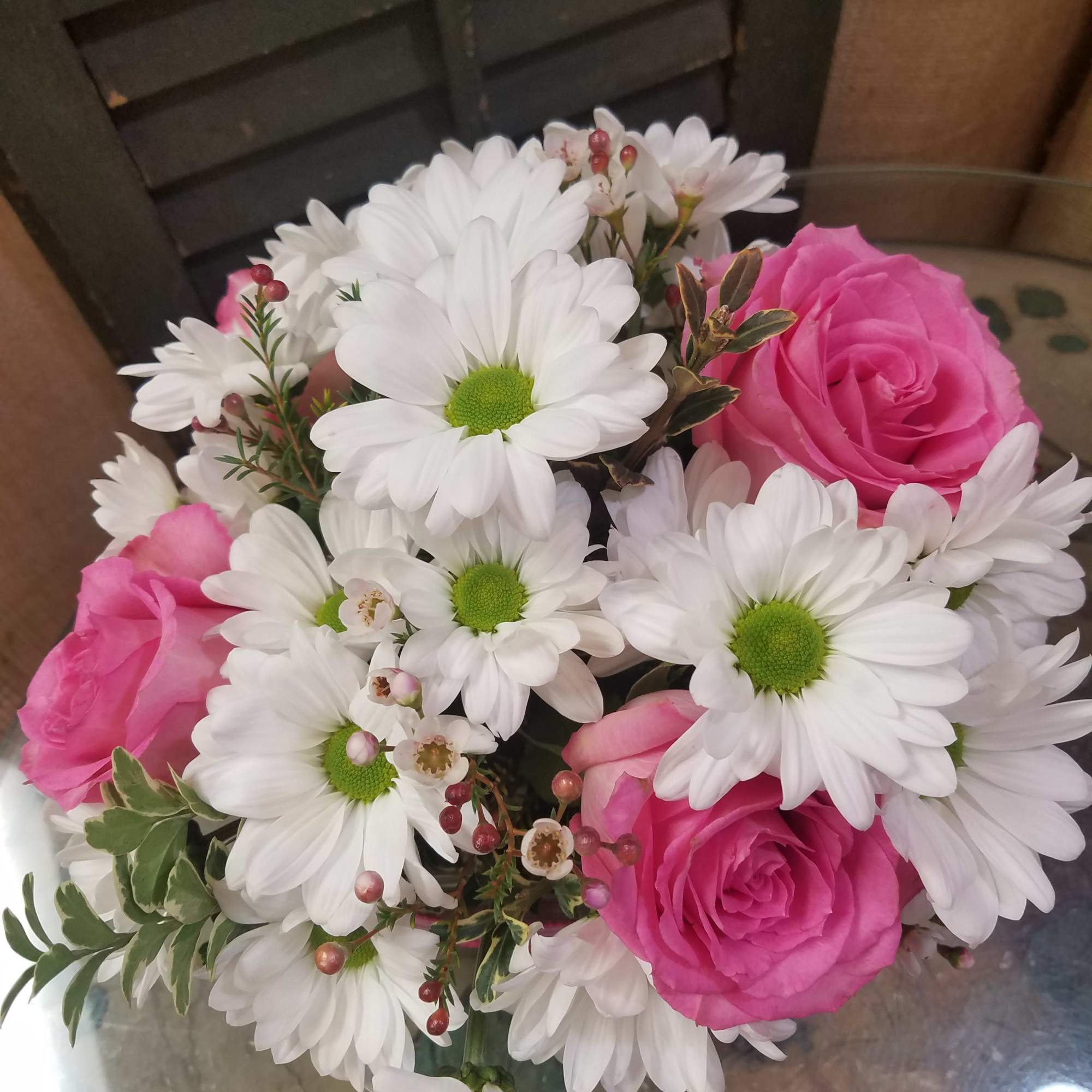Pink roses and white daisies arranged in a bouquet