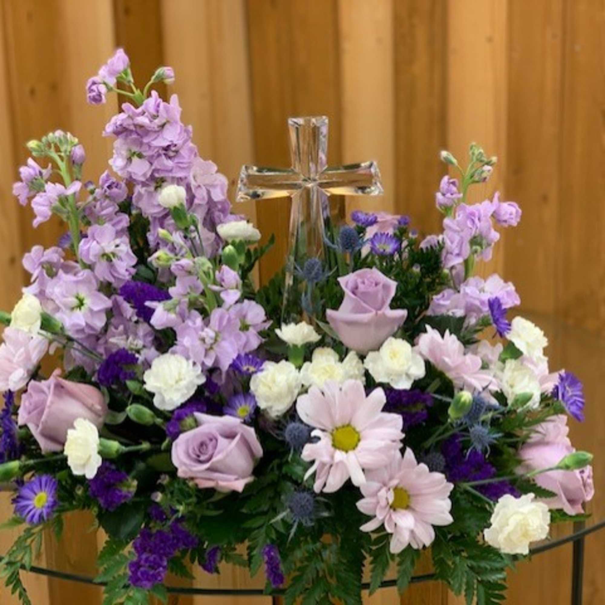 Lavender and white floral arrangement with a clear glass cross centerpiece