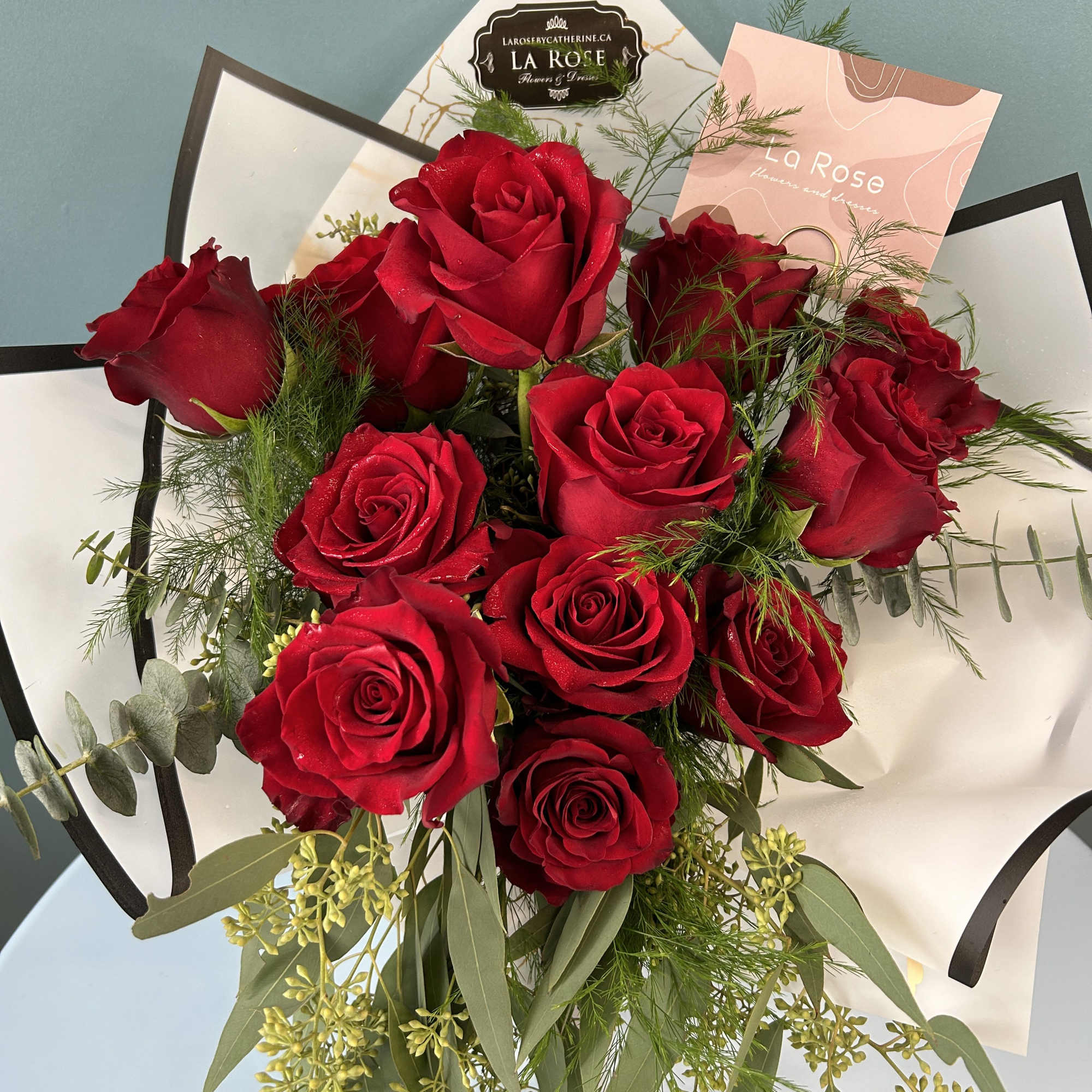 Bouquet of red roses with greenery and white wrapping