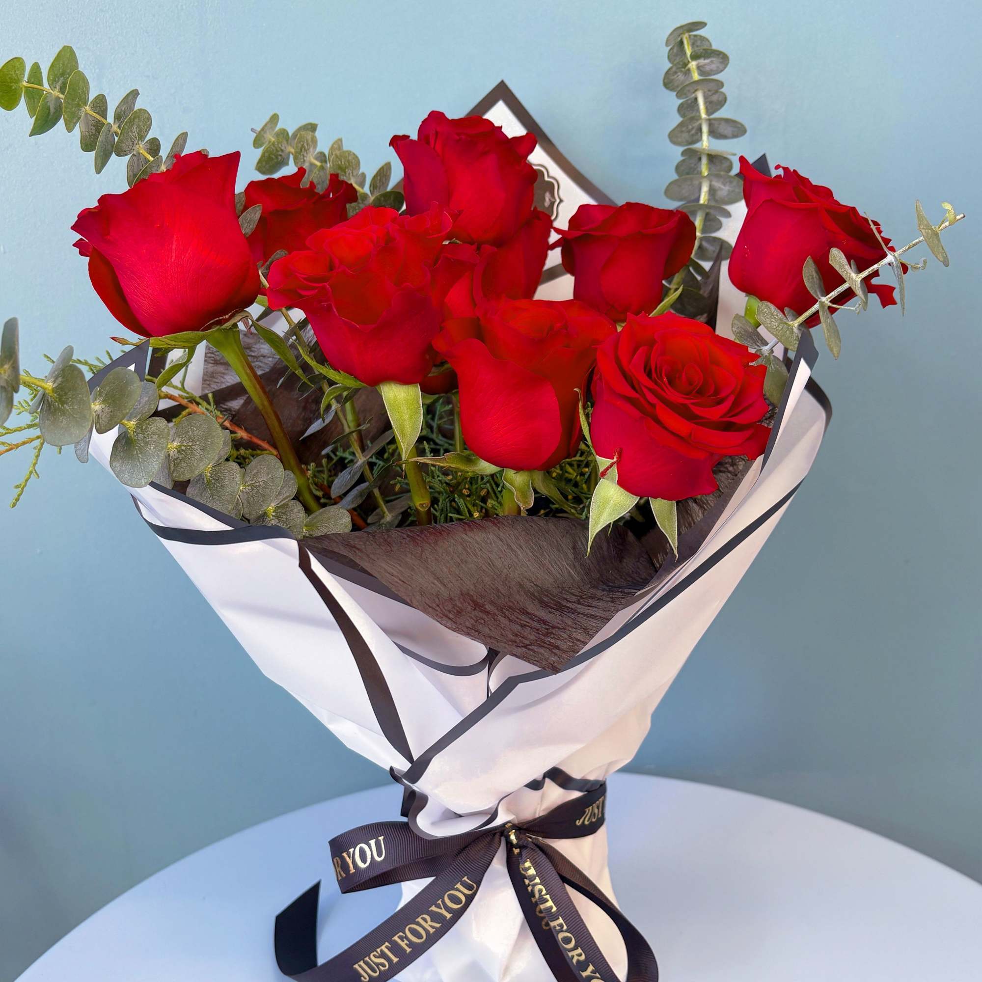 Bouquet of red roses wrapped in white paper with a black ribbon, photo 10 of 10