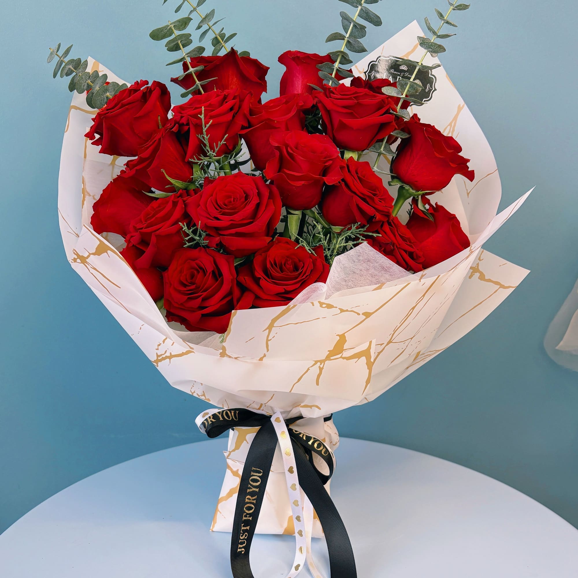 Bouquet of red roses wrapped in white paper with a black ribbon, photo 2 of 10