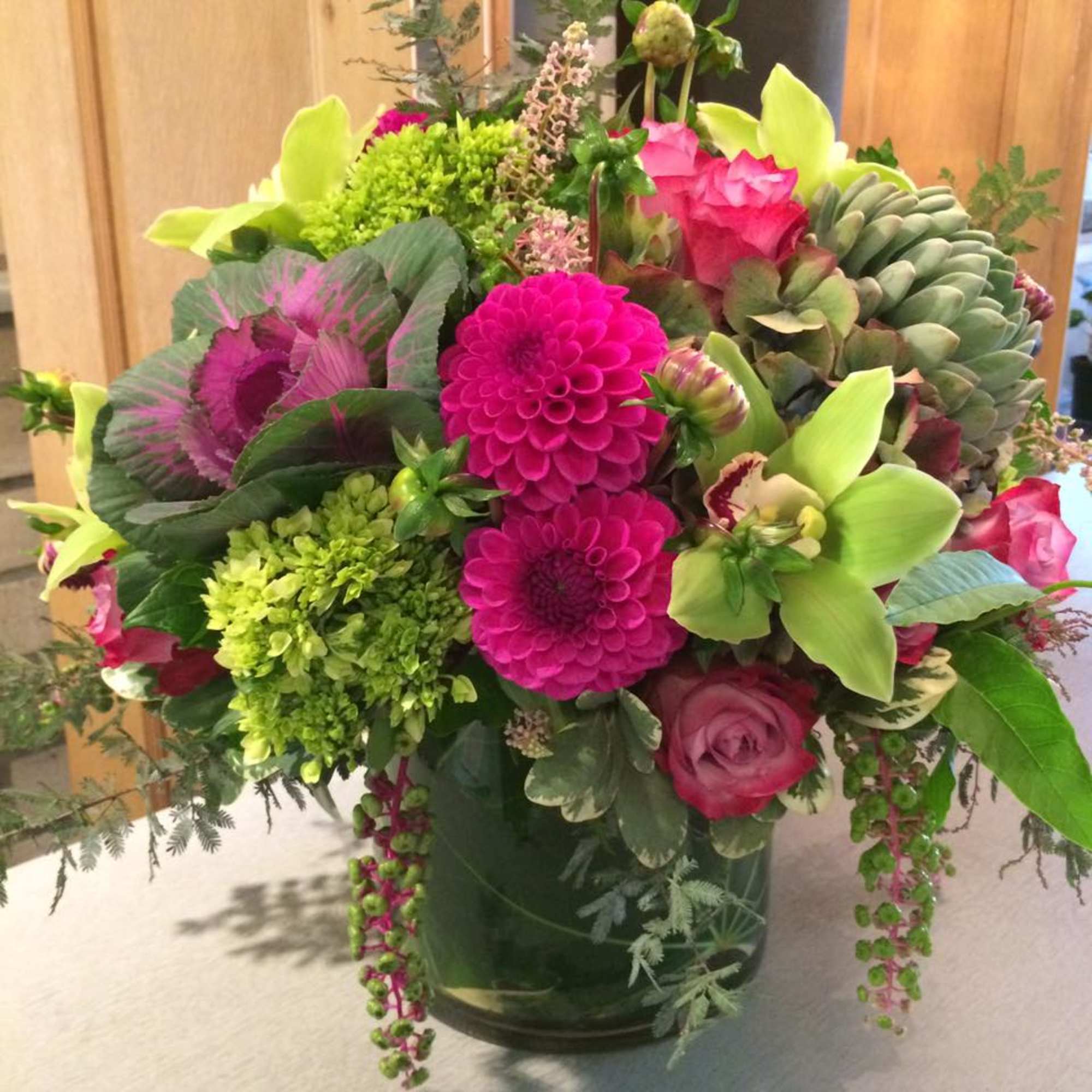 Bright mixed bouquet in a glass vase with pink and green blooms