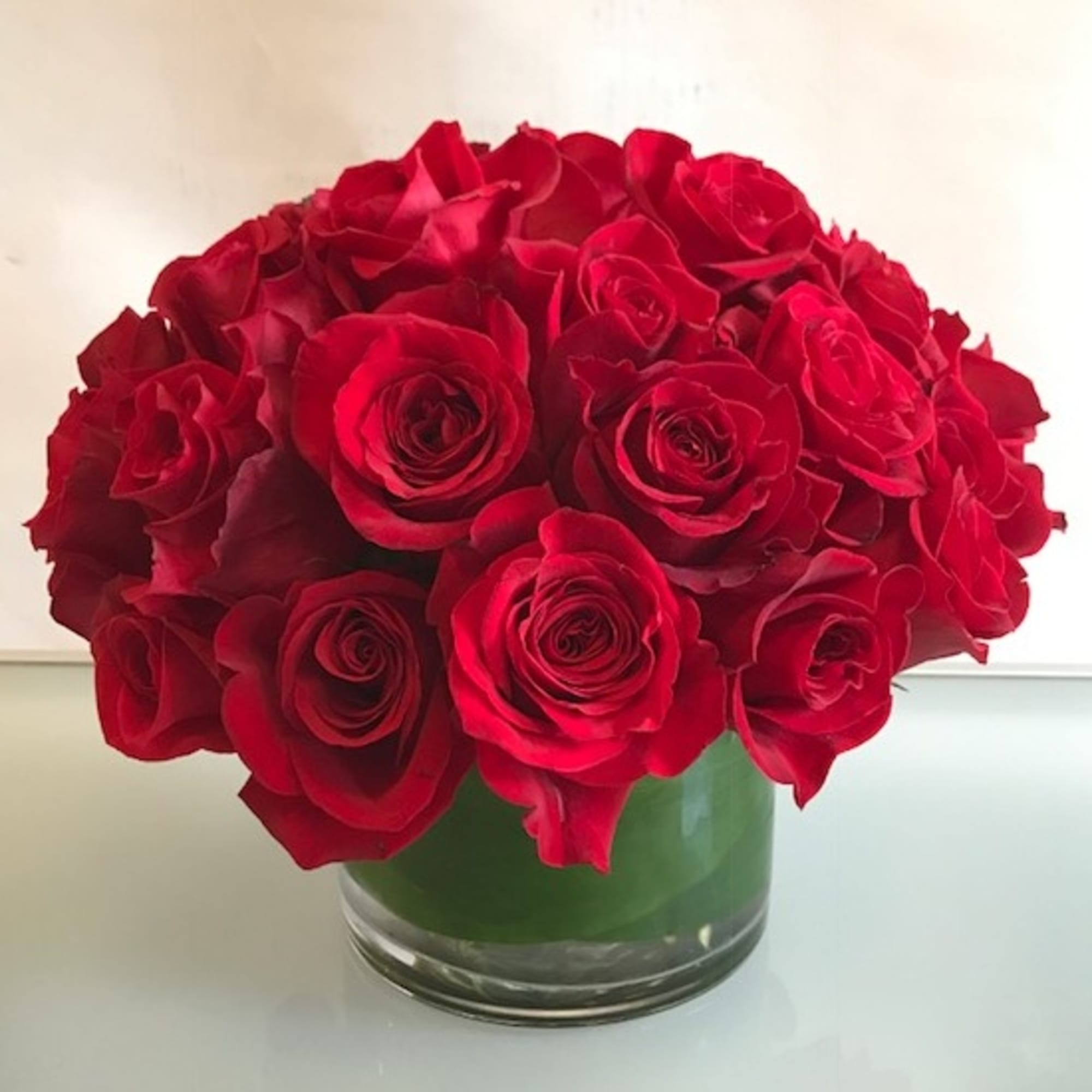Red roses arranged in a clear glass vase