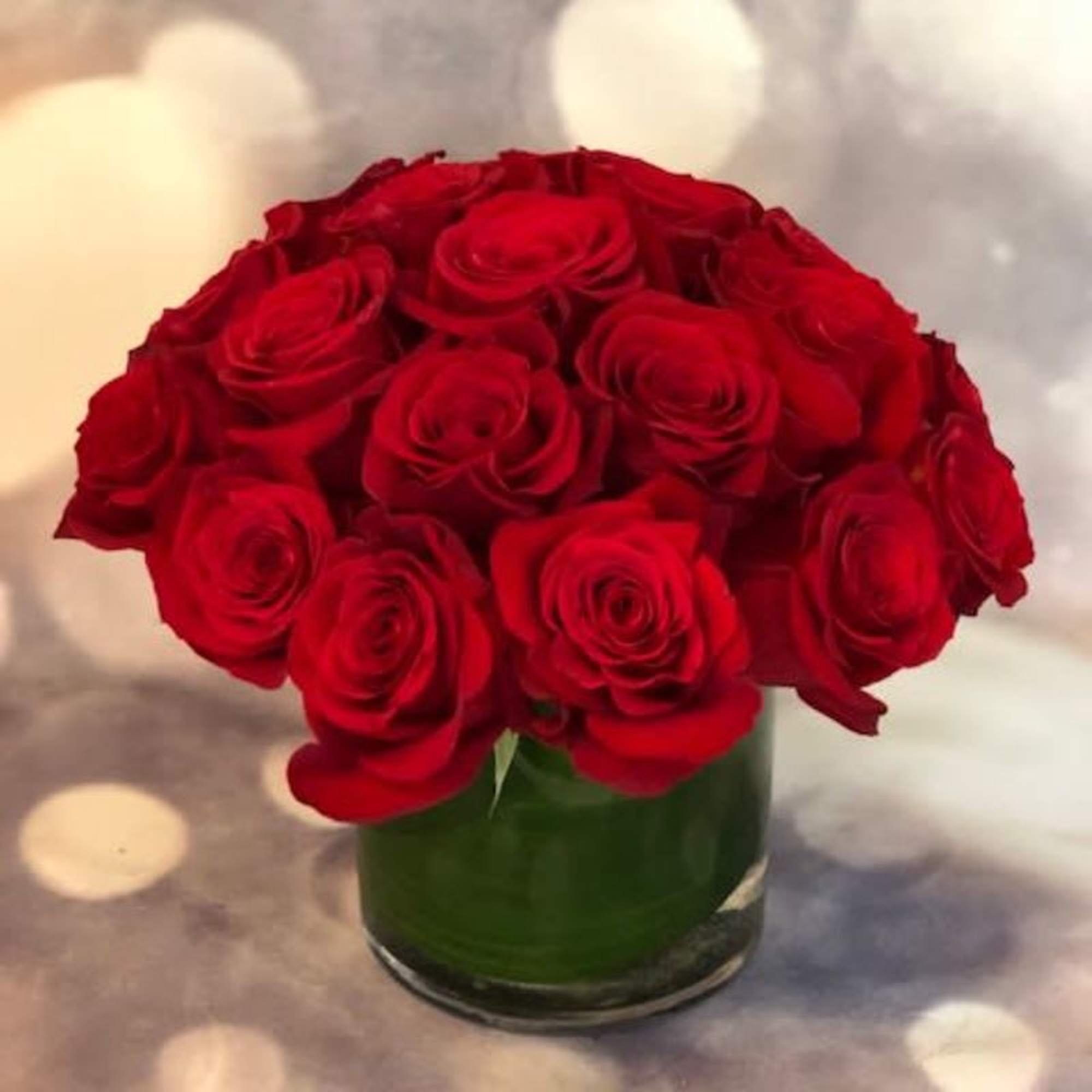 Red roses arranged in a clear glass vase