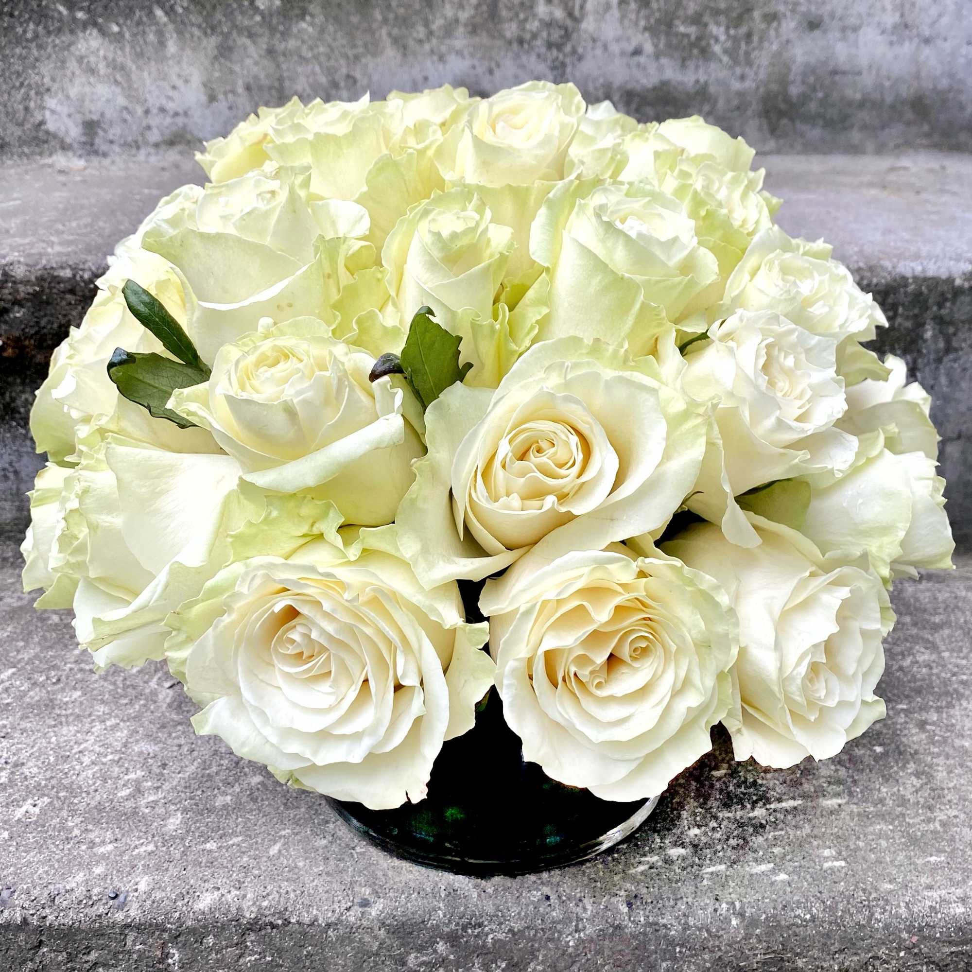 Bouquet of white roses in a black vase