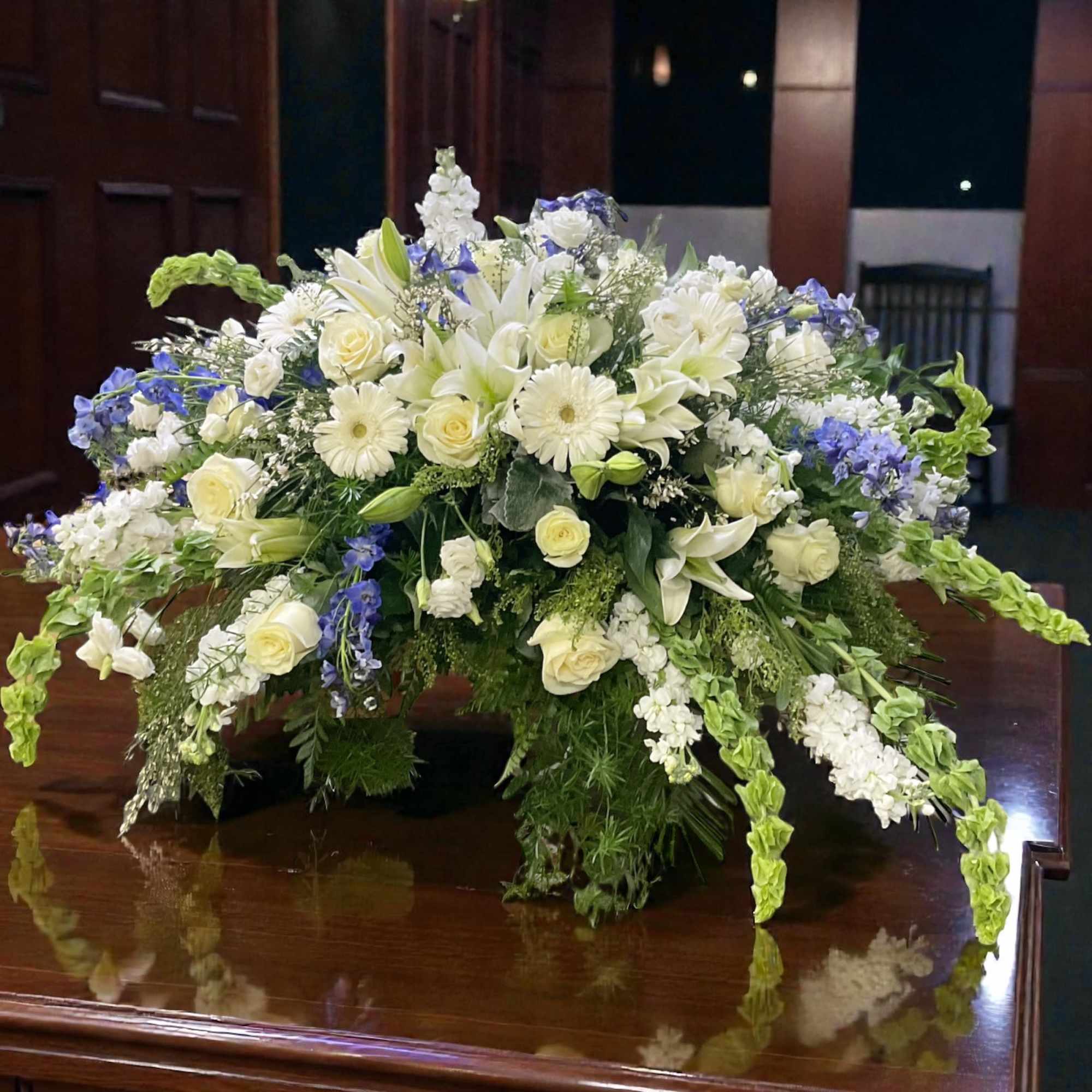 Beside the River is a serene white and blue casket spray designed