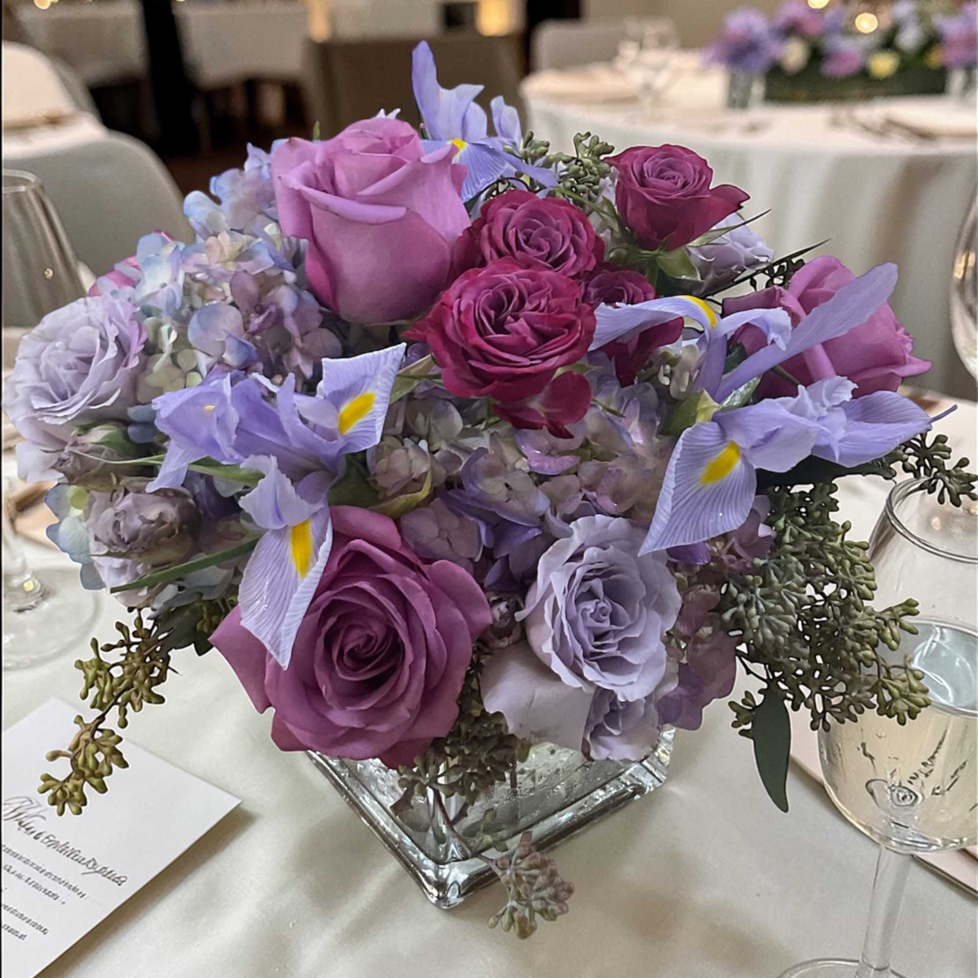 Lavender Skies Wedding Centerpiece features lavender roses, lavender spray roses, hydrangeas, iris