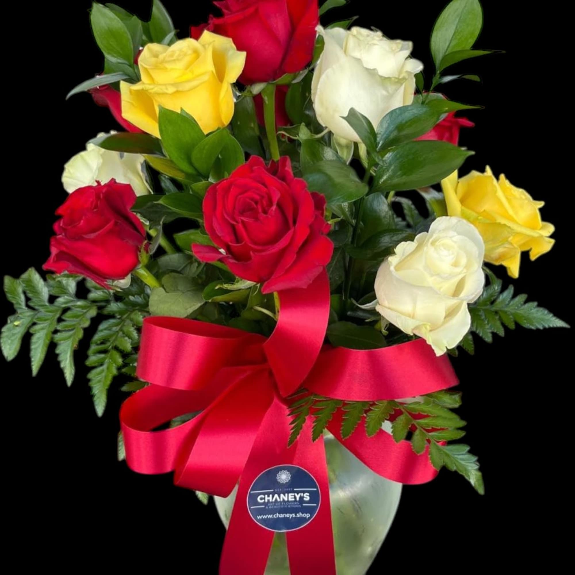 Bouquet of red, yellow, and white roses in a glass vase with a red ribbon