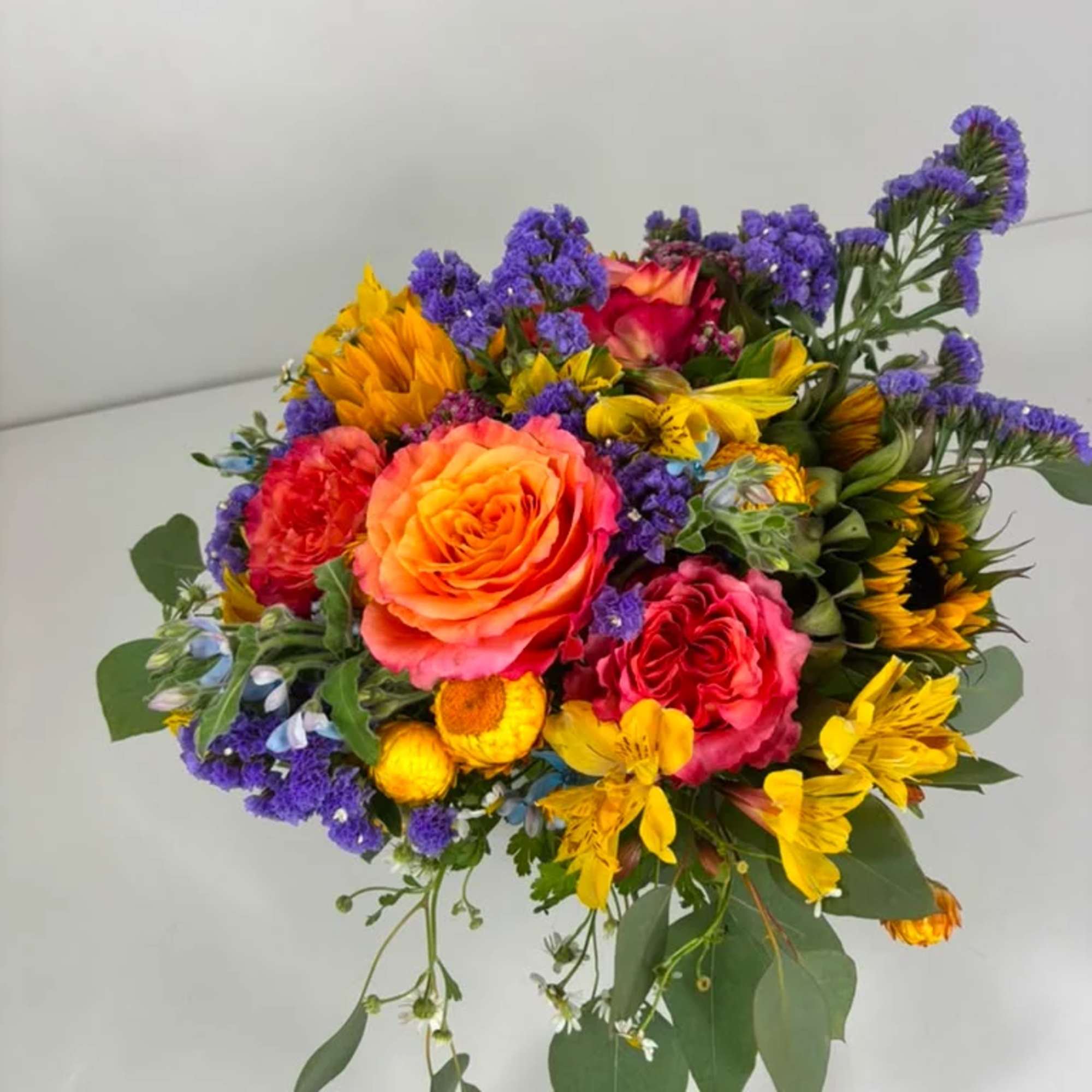 Colorful bouquet of roses, sunflowers, and yellow blooms