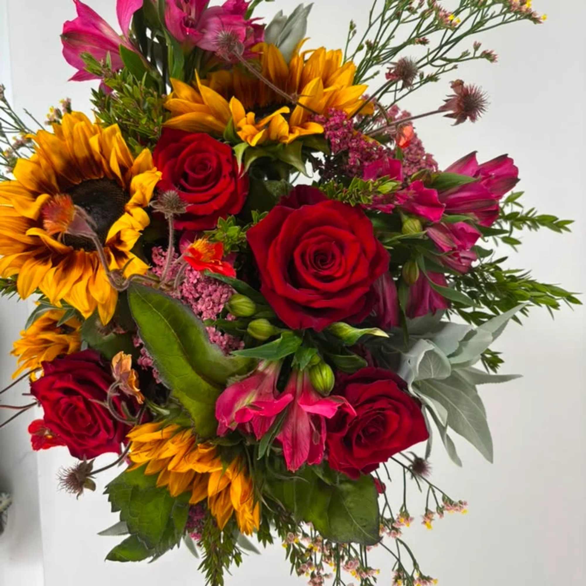 Bouquet of red roses, sunflowers, and pink alstroemeria