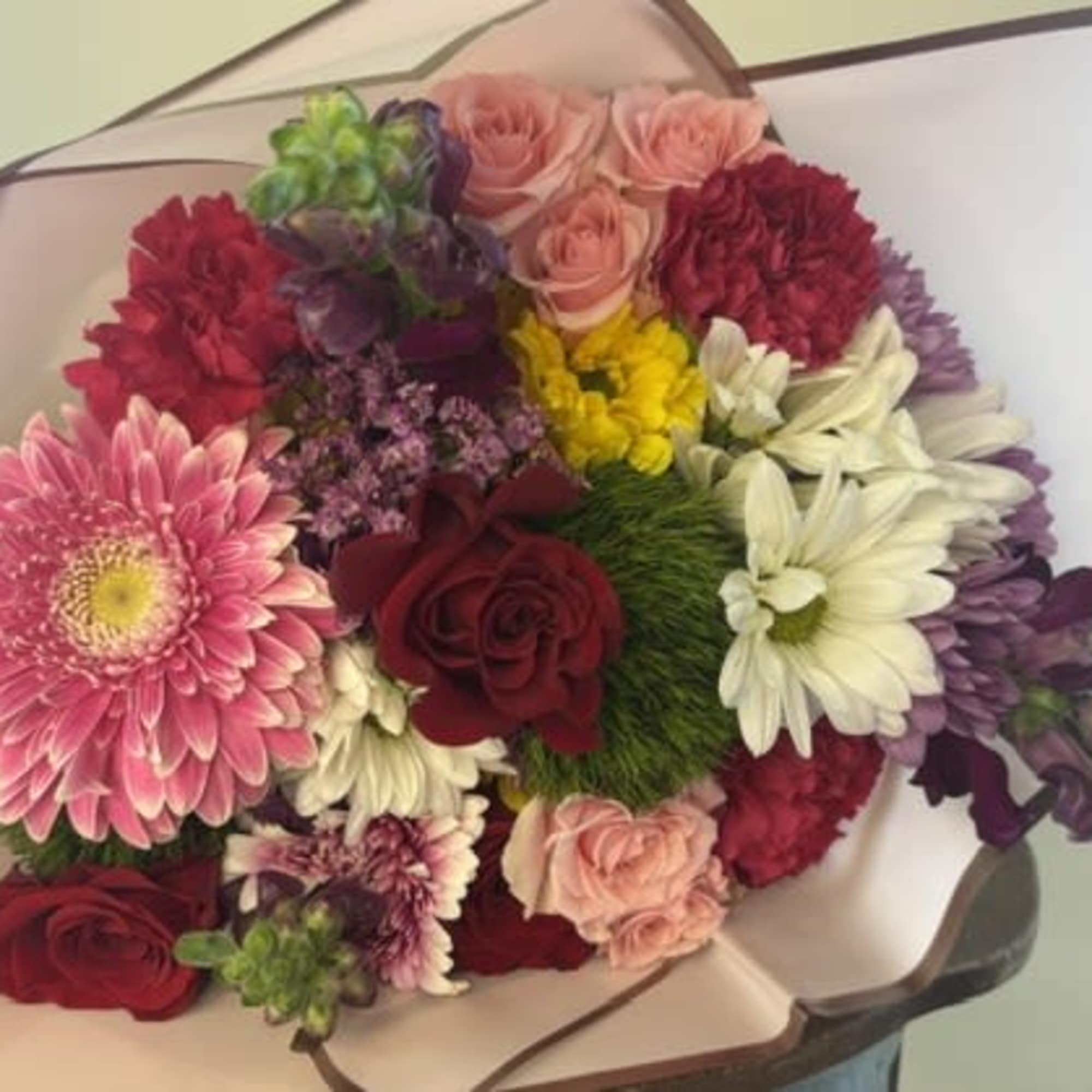 Our Garden Selection is a hand-wrapped designer's choice bouquet (vase not included)