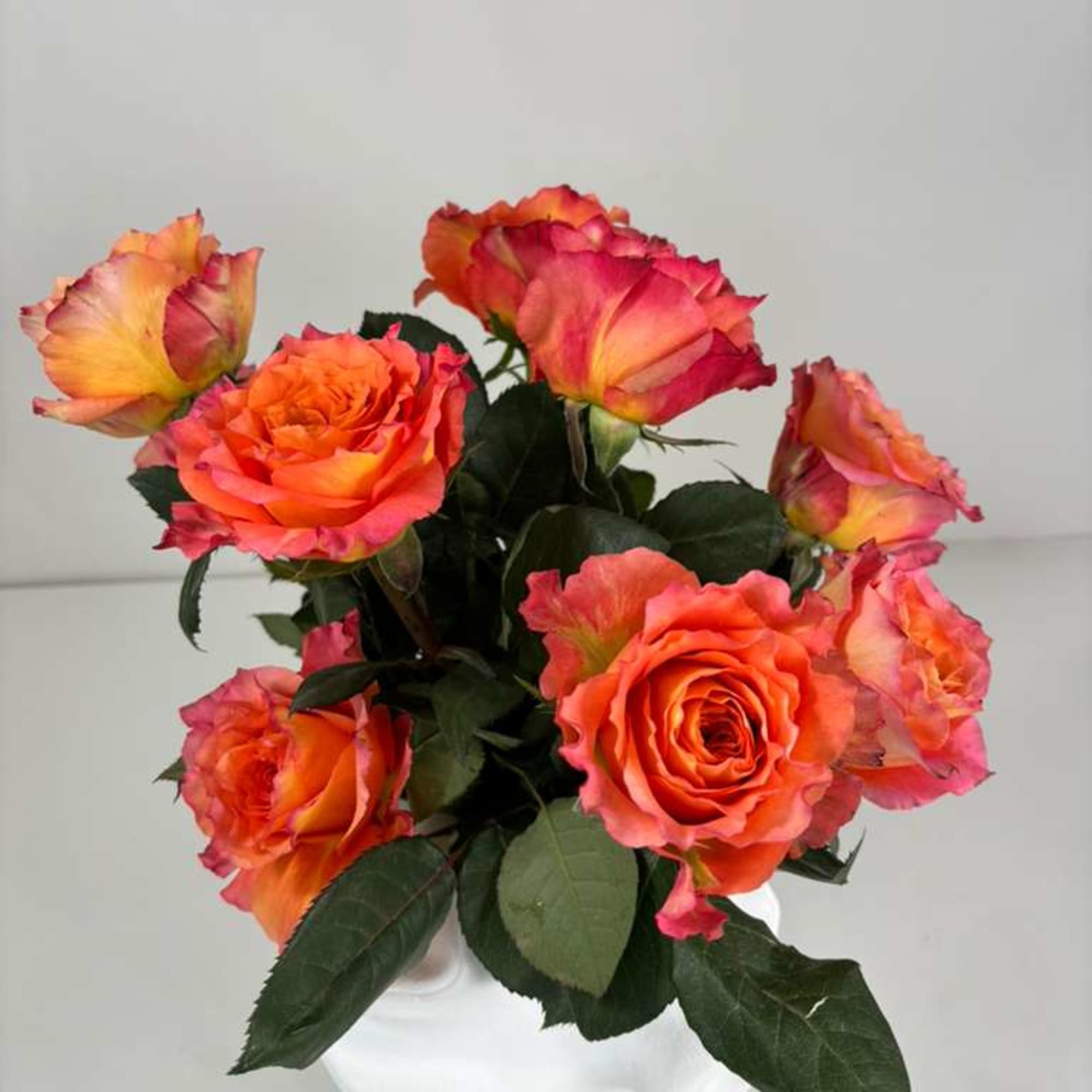 Bouquet of orange and pink roses in a white vase, photo 3 of 4