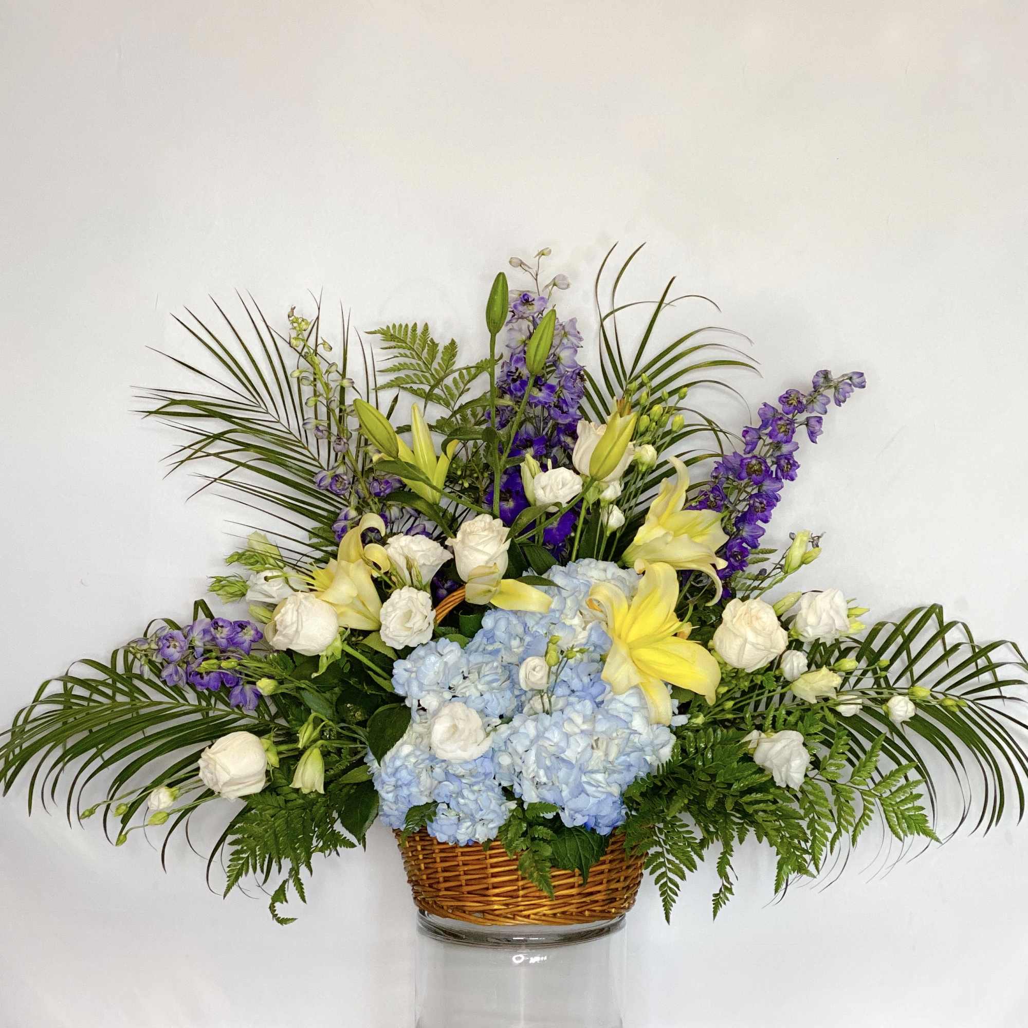 A blue, white, and green funeral basket for any type of service.