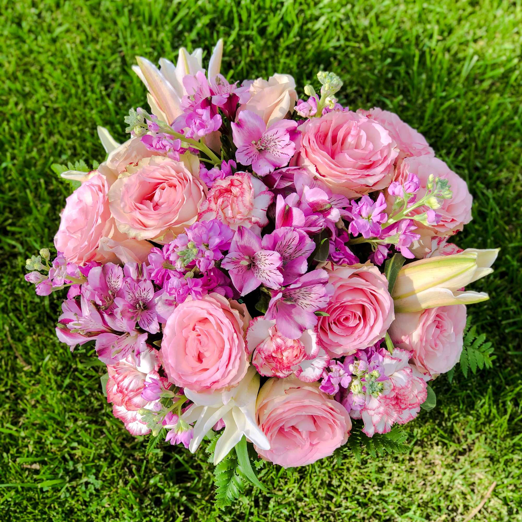 Pink bouquet with roses, lilies, and small purple flowers